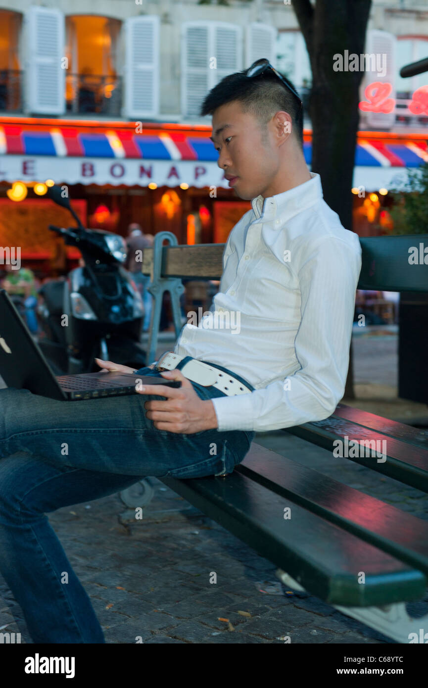 Ritratto, giovane uomo, studente di scambio cinese fuori strada, Parigi, Francia, utilizzando laptop, quartiere 'Saint Germain des Pres', uomo asiatico fuori Foto Stock