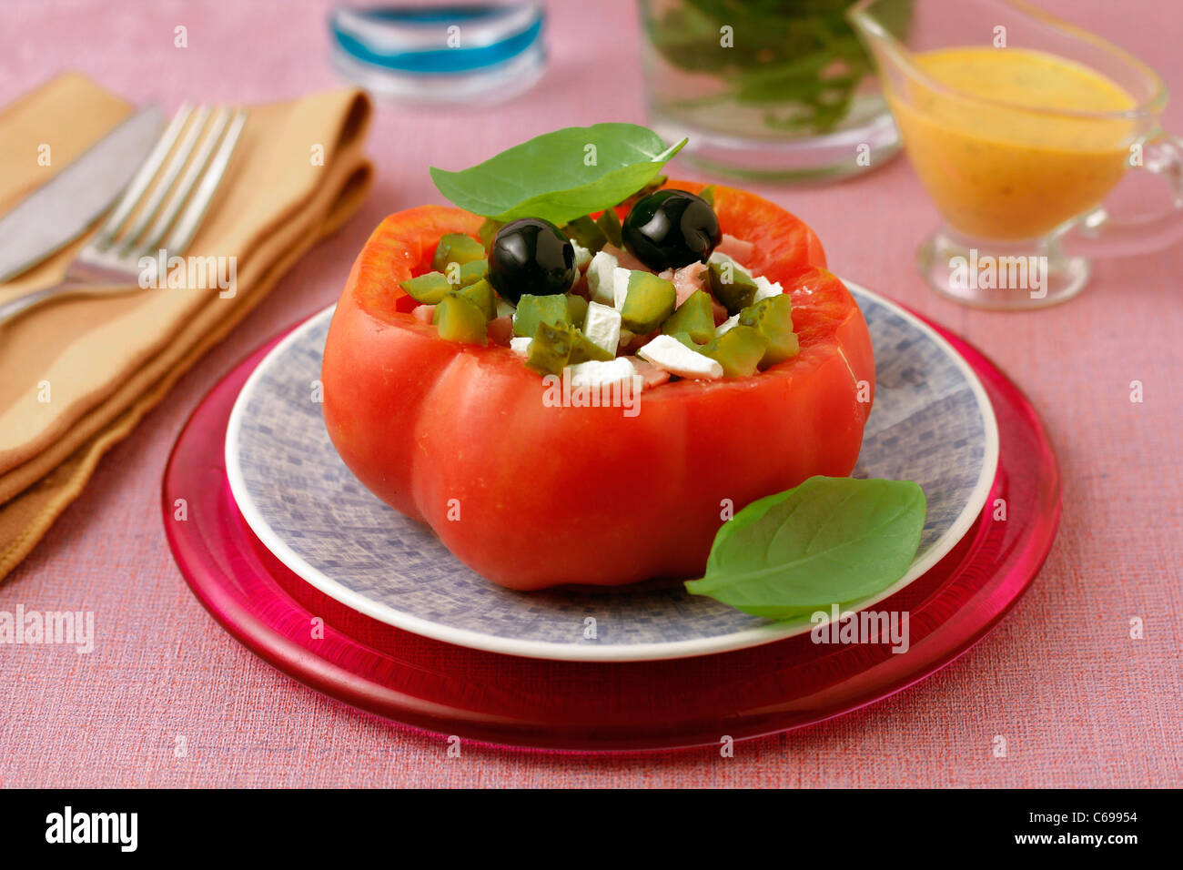 Pomodorini ripieni con salsa di basilico. Ricetta disponibile. Foto Stock
