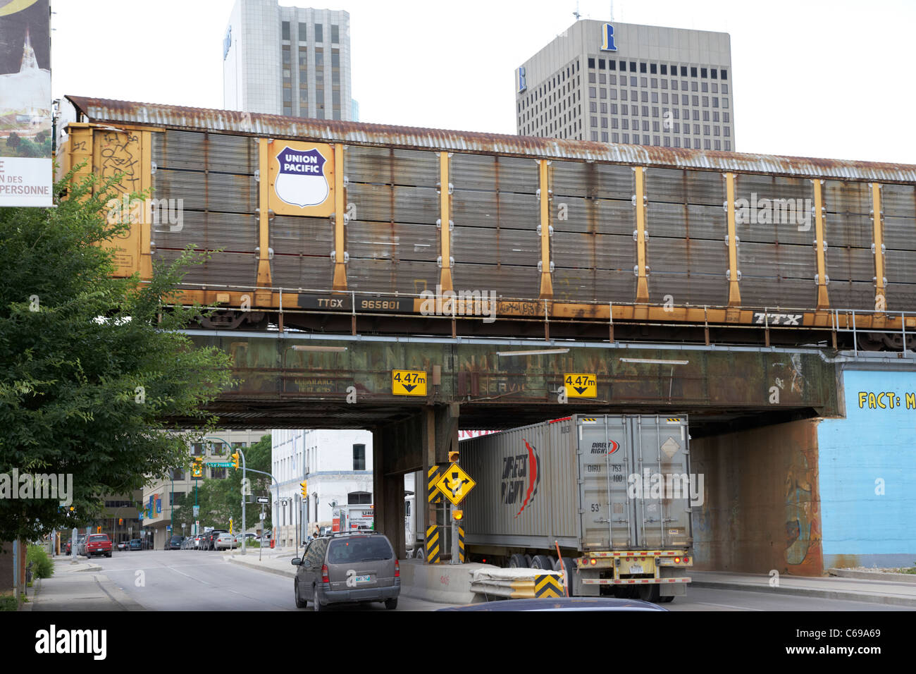 Union Pacific convoglio ferroviario passando sul metallo ponte ferroviario nel quartiere finanziario del centro cittadino di Winnipeg Manitoba Canada motion Foto Stock