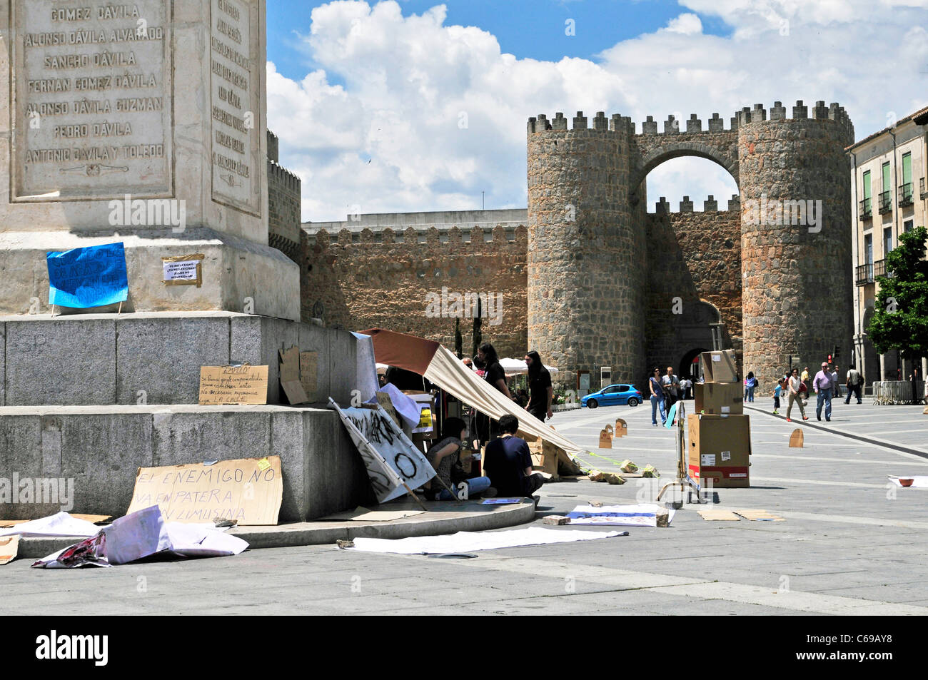 "Indignants' segni di protesta contro il fondale di medievale Avila parete in Spagna in Plaza Santa Teresa Foto Stock