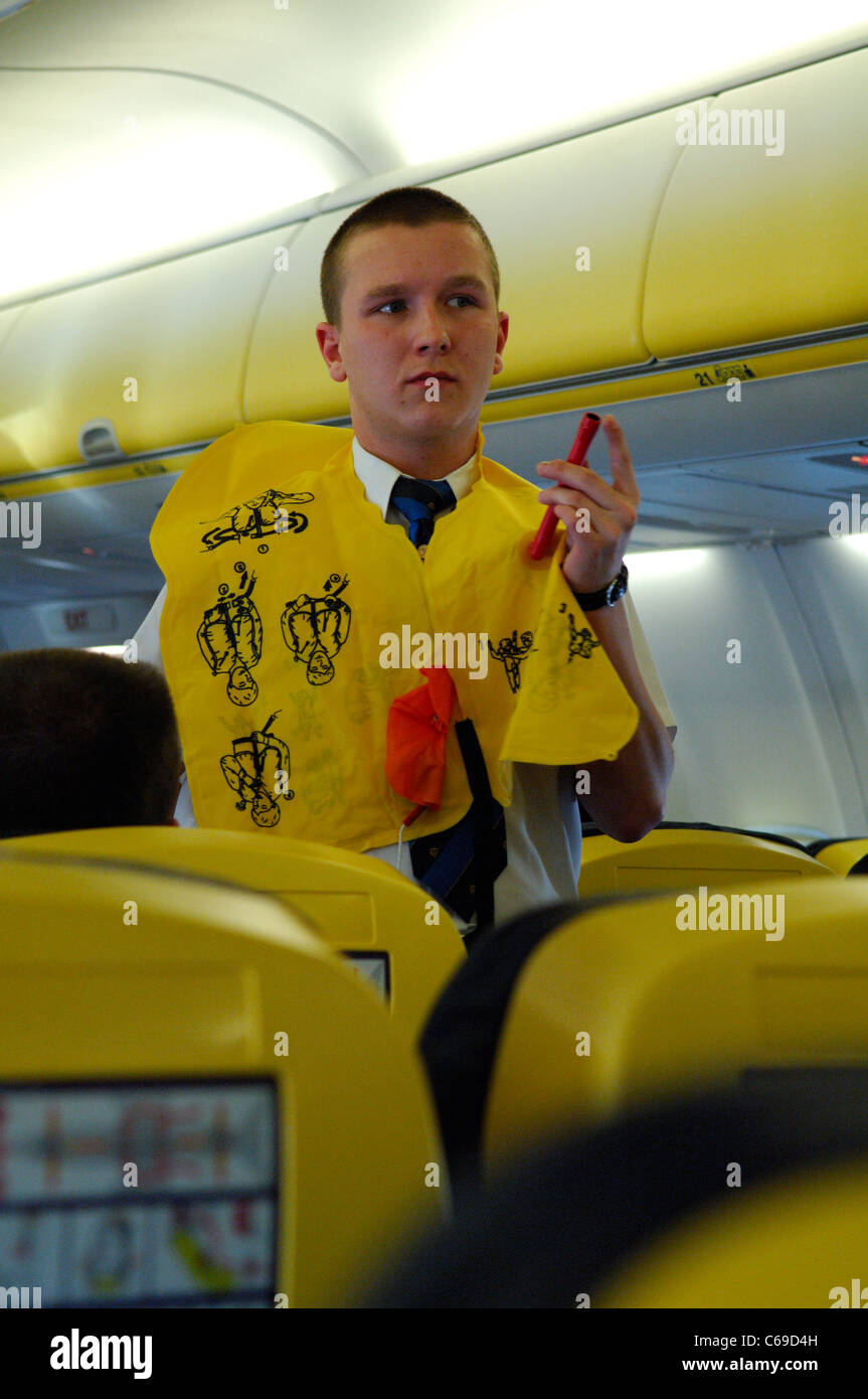 Steward che mostra informazioni di sicurezza a passeggeri di Ryanair Boeing 737 Foto Stock