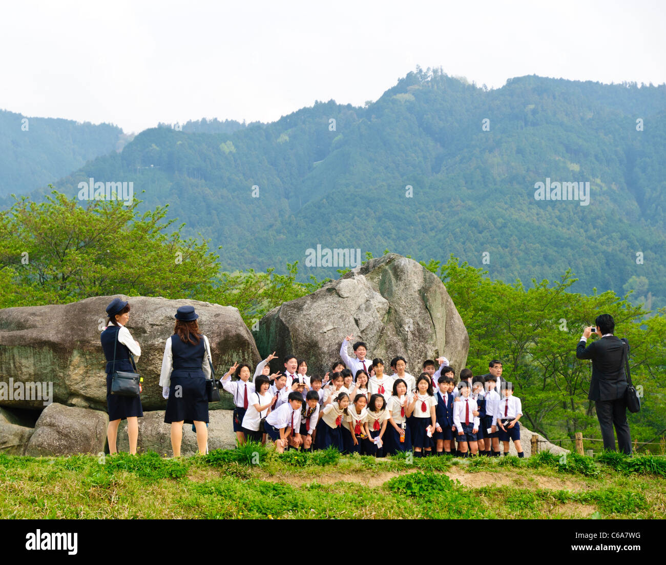 Asiatico i bambini della scuola hanno le loro foto scattata davanti i resti di una antica sepoltura camera o kofun Foto Stock