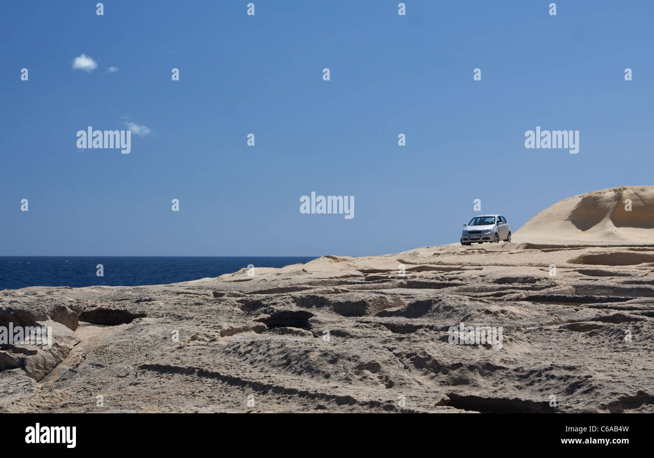 Macchina parcheggiata su rocce vicino saline, vicino Qbajjar, Marsalfon, Gozo, Malta Foto Stock