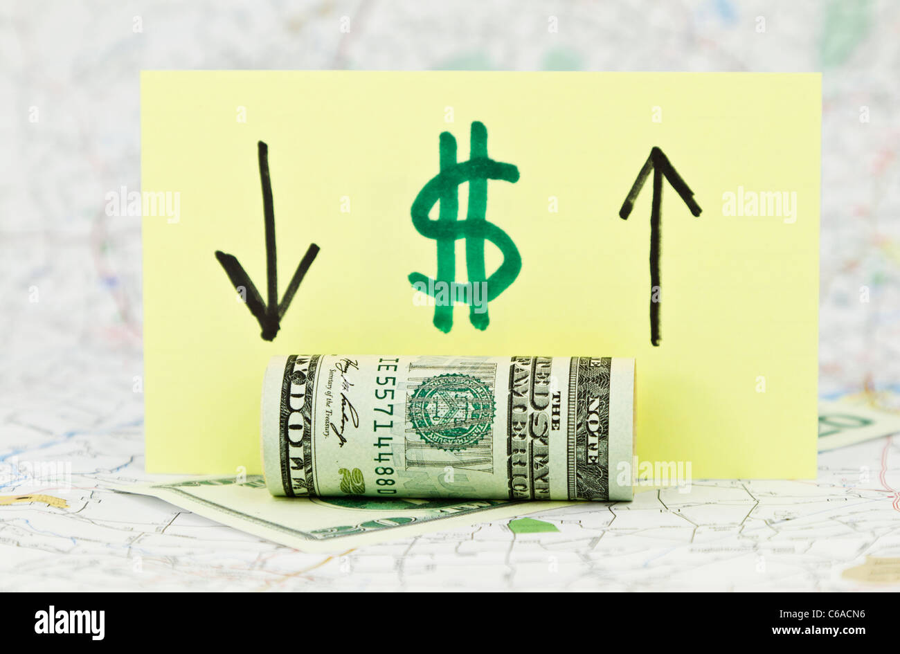 Dollaro americano valuta nella parte anteriore del cartellino giallo con il simbolo del dollaro e le frecce in su e in giù, con lo sfondo della mappa. Foto Stock