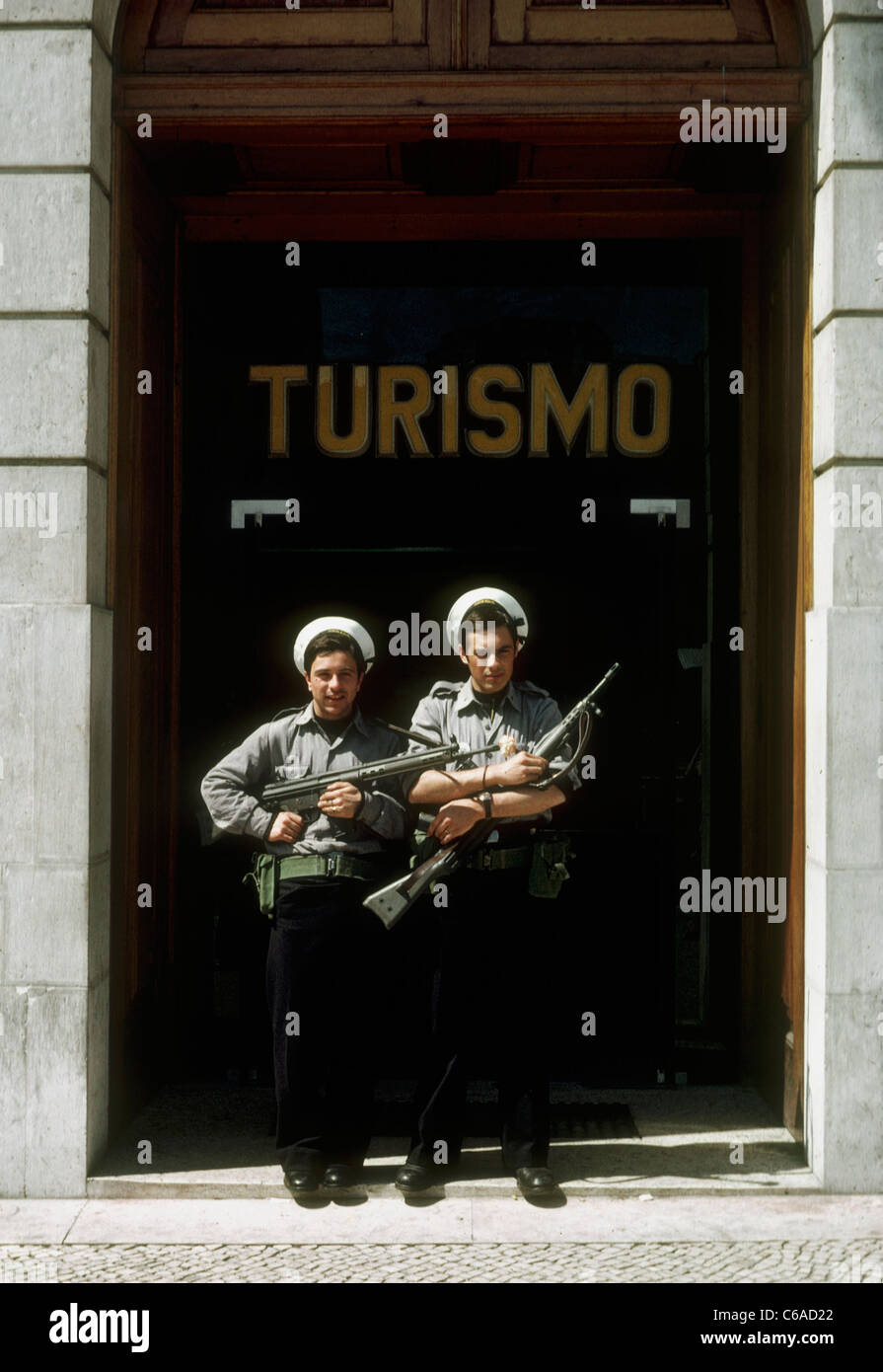 I marines portoghesi sono guardiani fuori dall'ufficio del turismo di Lisbona, con i fiori nelle loro pistole, dopo la 'rivoluzione del garofano, il colpo di stato militare senza sangue del 25 aprile 1974 che depose il regime autoritario di Salazar e iniziò la transizione del Portogallo alla democrazia Foto Stock