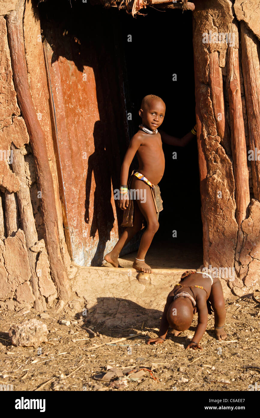 Himba bambini davanti a casa nel villaggio nei pressi di Opuwo, Namibia Foto Stock