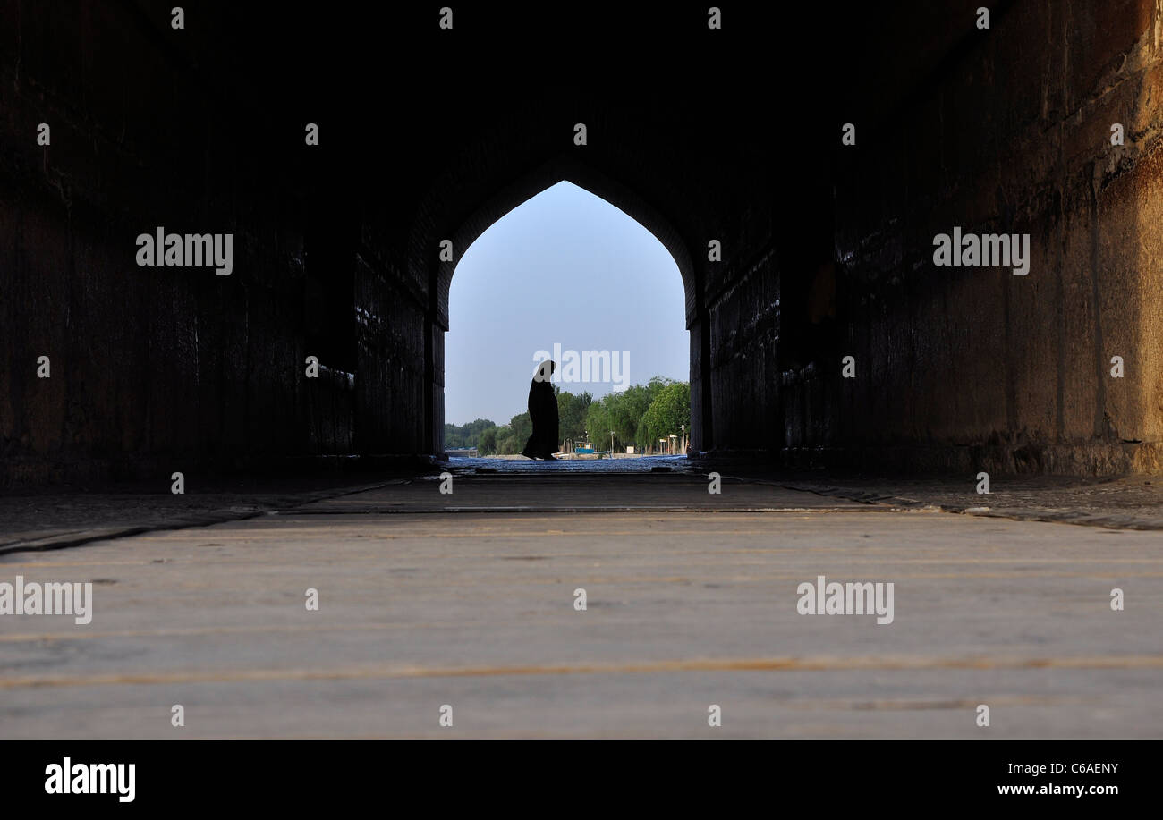 Una donna iraniana passando per Ponte Khaju, Isfahan Iran. Foto Stock