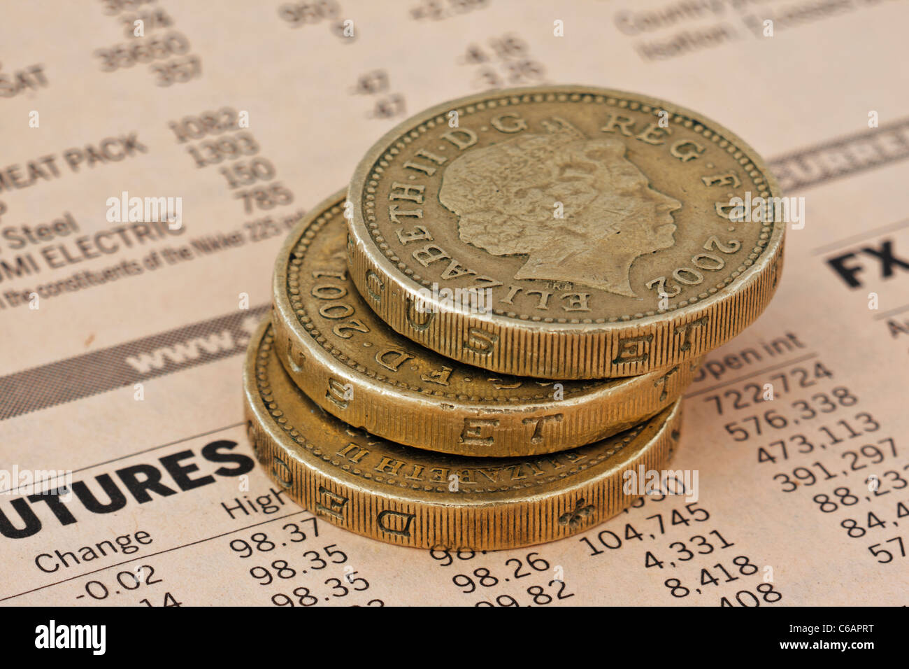 Close up libre tre monete in una pila di una pagina dal Financial Times Foto Stock