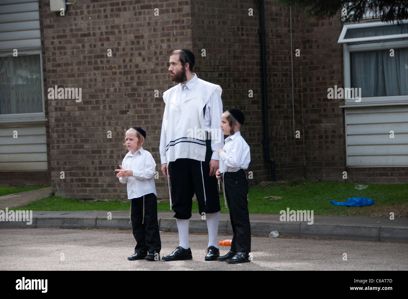 Hackney Stamford Hill Hackney 13 Agosto 2011.Hasidic uomo e bambini guardare la pace marzo dopo i tumulti, da Gillett Square Foto Stock