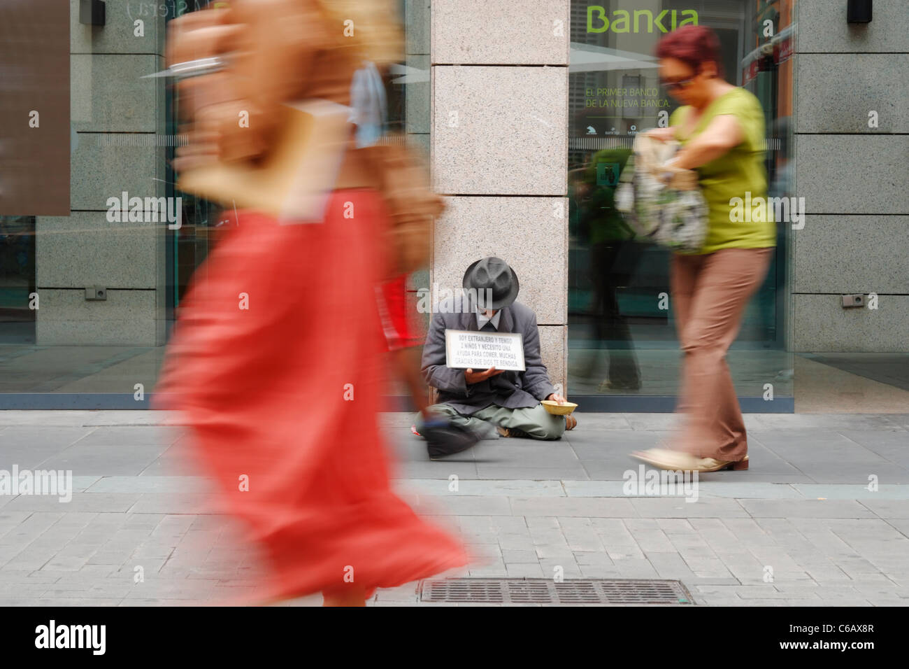 Uomo di accattonaggio al di fuori del ramo della banca Bankia in Spagna. Foto Stock