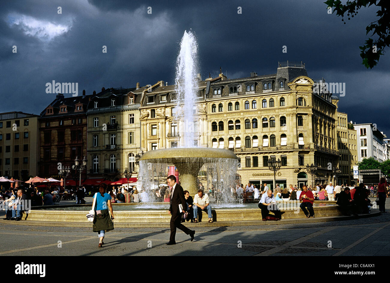 La gente del posto in appoggio intorno alla fontana Lucae su Opernplatz (Opera Square) ad Alte Oper nella città di Francoforte am Main. Foto Stock