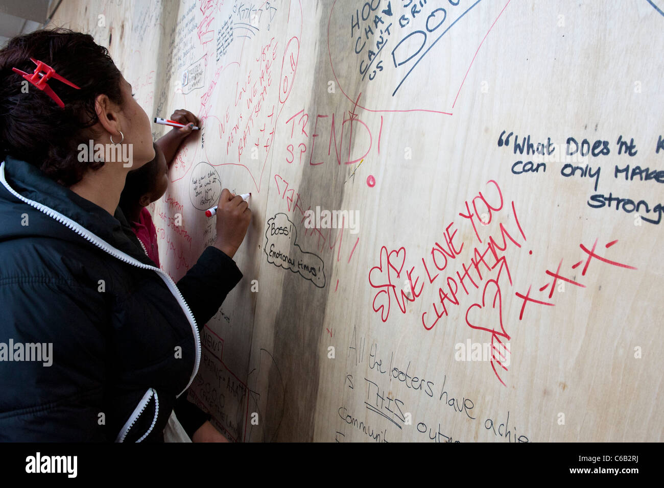 Le conseguenze dei tumulti in Clapham Junction area. Le persone scrivono messaggi di sostegno su schede a copertura dei danni. Foto Stock