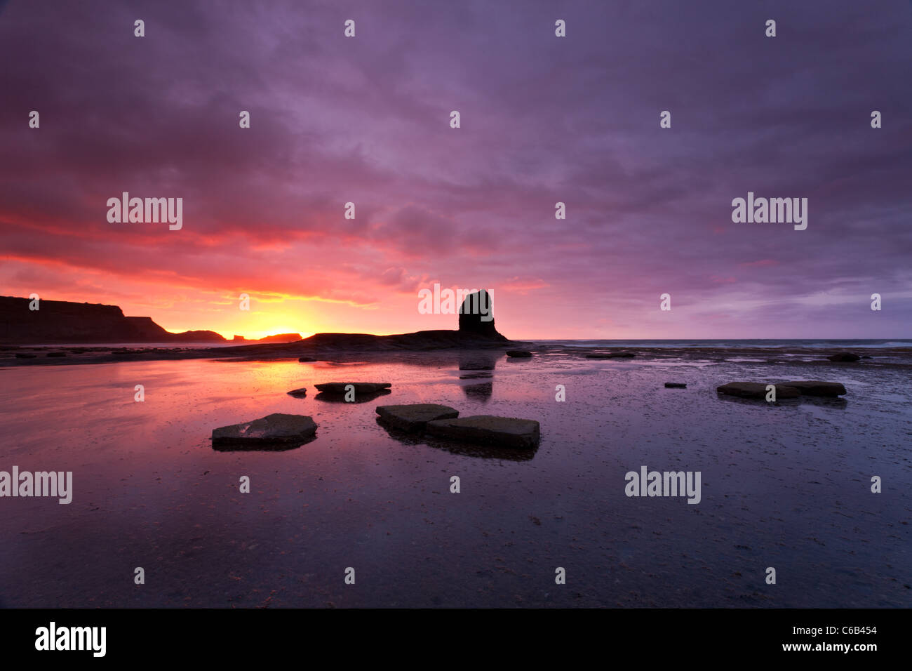 Tramonto e nero mare Nab Stack, Saltwick Bay, Whitby, North Yorkshire Foto Stock