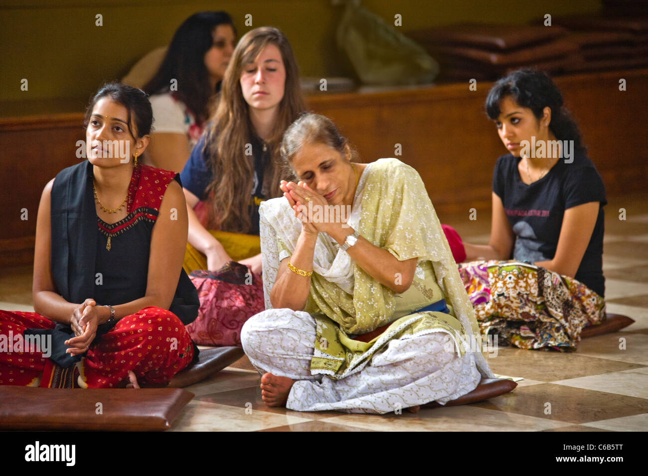 Sia indiana e donne americane di culto in un tempio indù in Laguna Beach, CA. Nota sari indiani abito nativo. Foto Stock