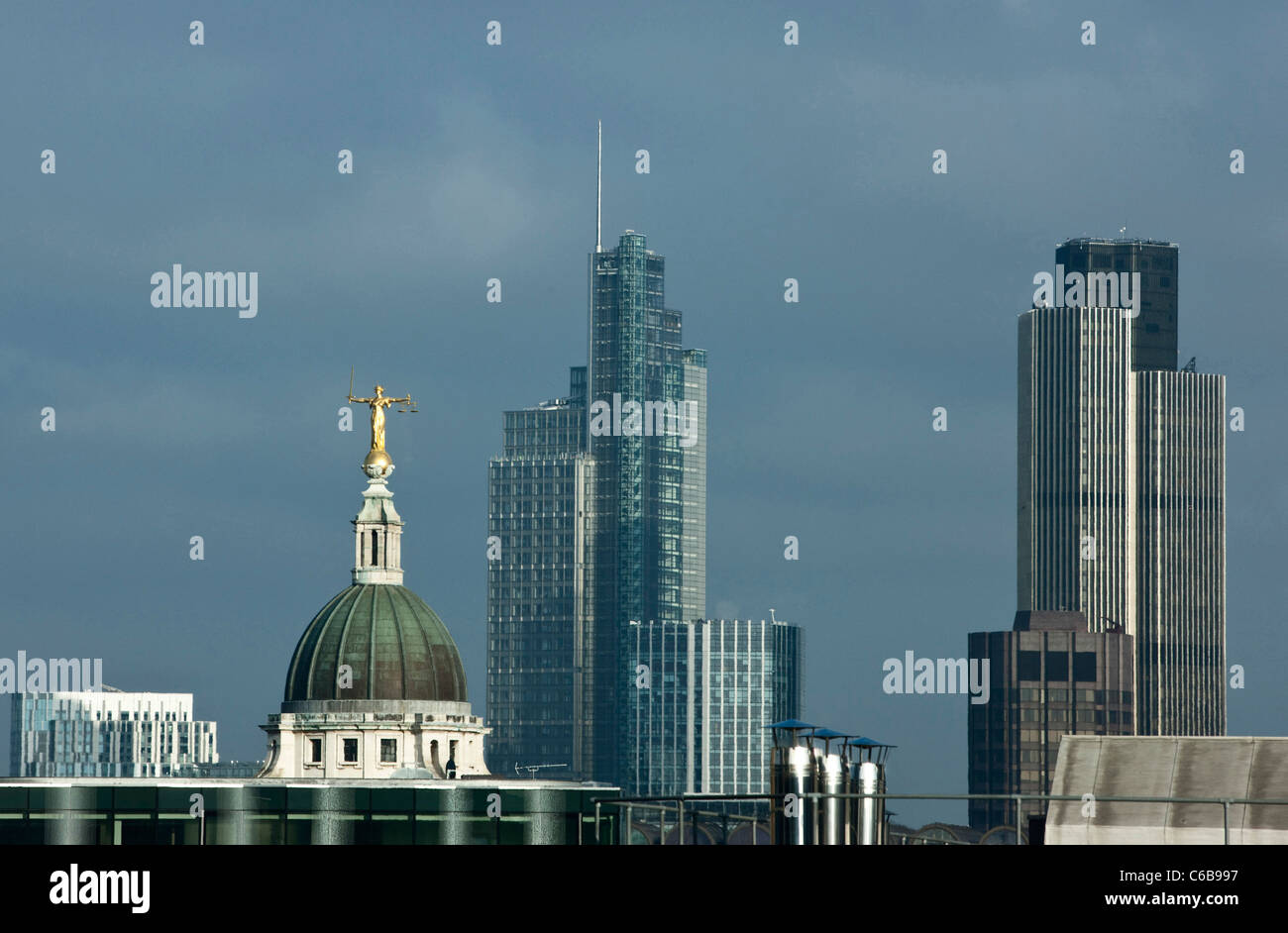 Signora giustizia sorge in alto sulla cima della Old Bailey tribunali con la città di Londra in background. Londra, Regno Unito. Foto Stock