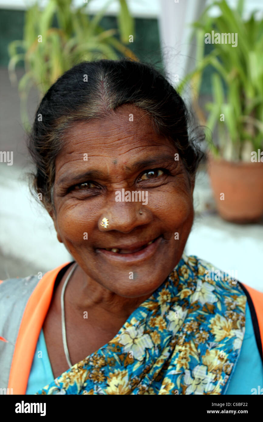 Il montante verticale di sorridere donna indiana spazzatrice; ella è gap-dentata Foto Stock