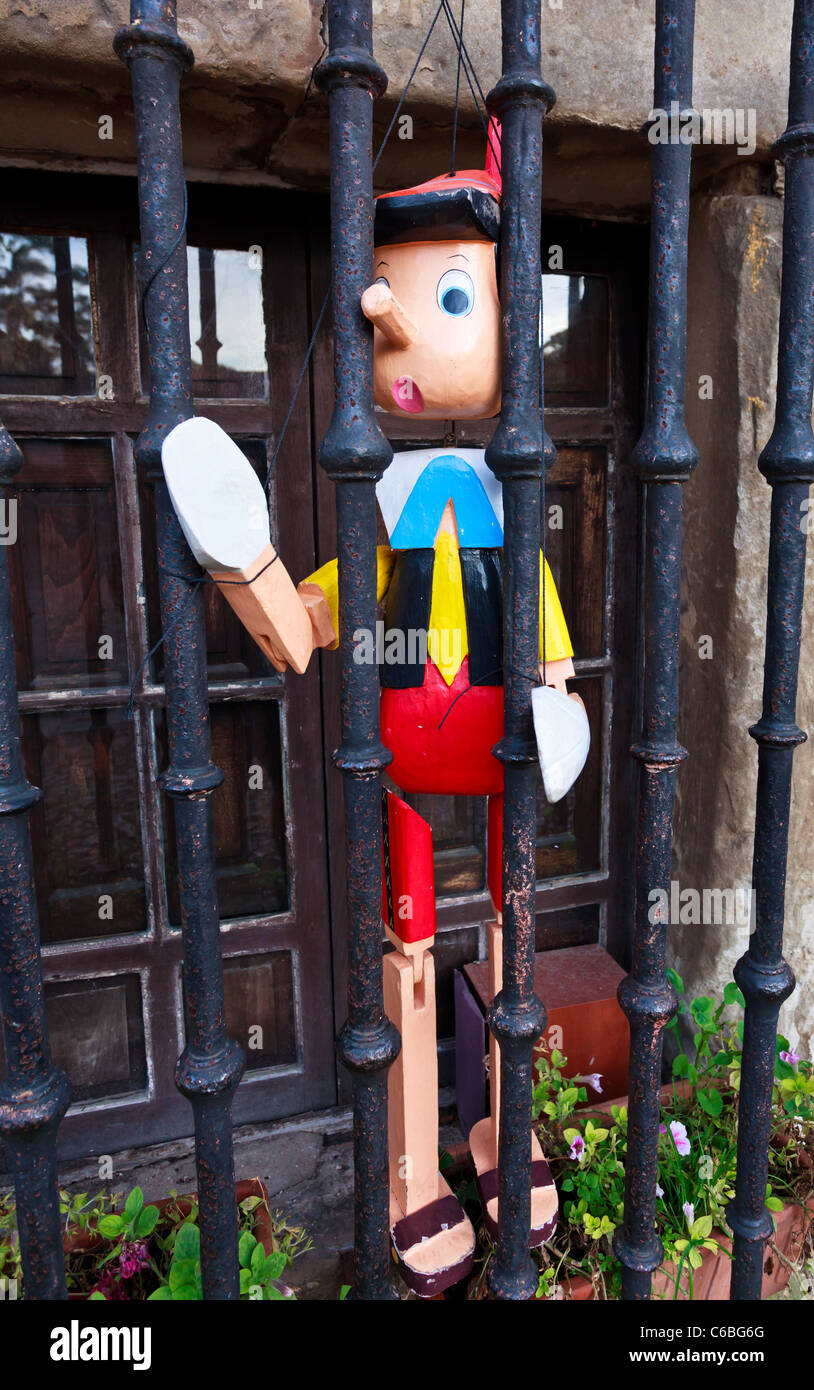 Pinocchio burattino collocato dietro la finestra barre, Santillana del Mar, Cantabria, SPAGNA Foto Stock
