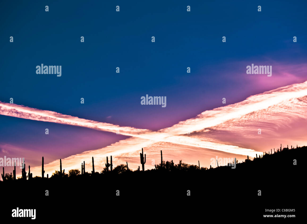 Un tramonto con due contrails facendo una X. Foto Stock