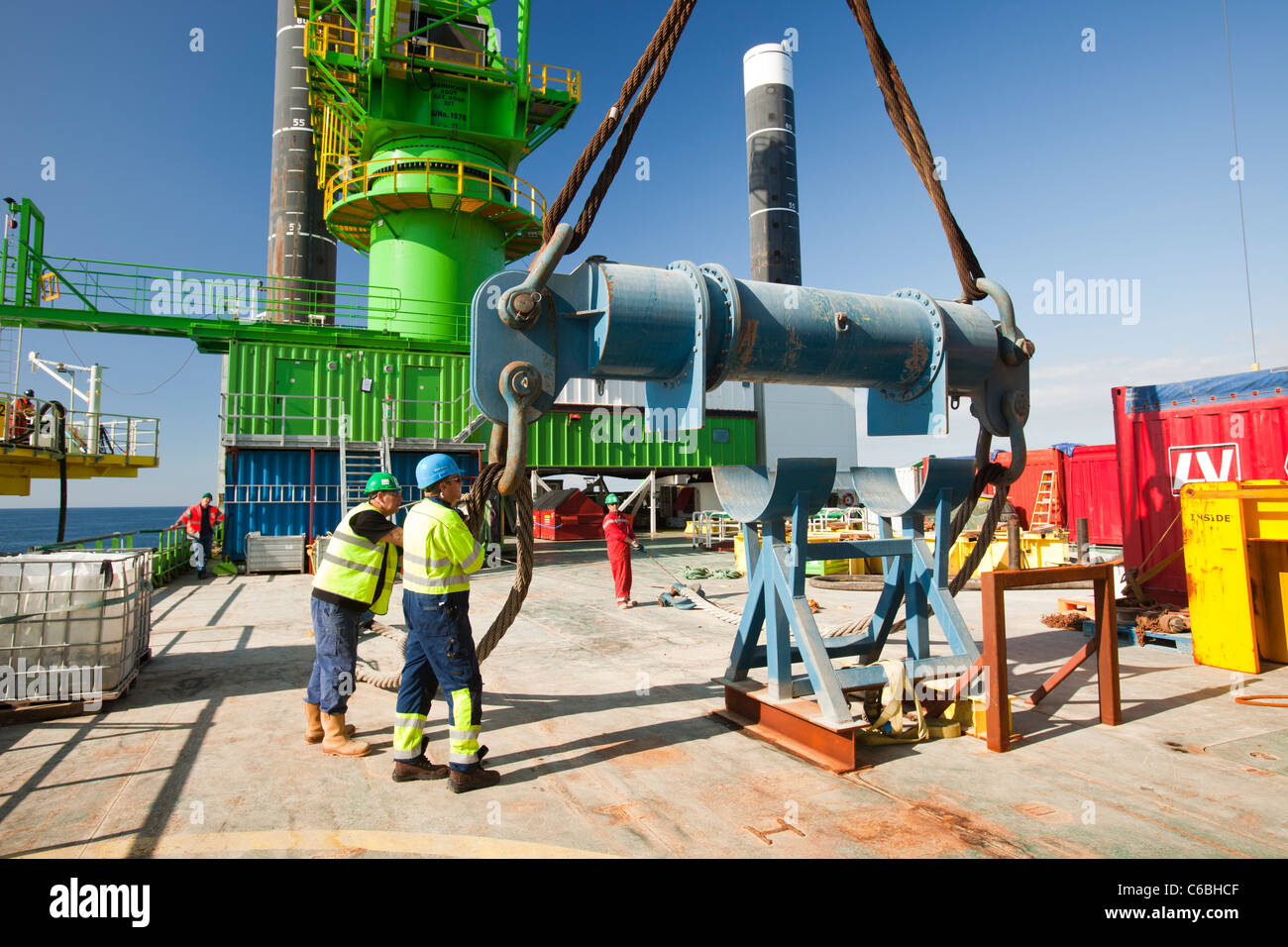 Lavoratori su un jack up barge lavorando sul Walney offshore wind farm, preparare per sollevare un pezzo di transizione in posizione. Foto Stock