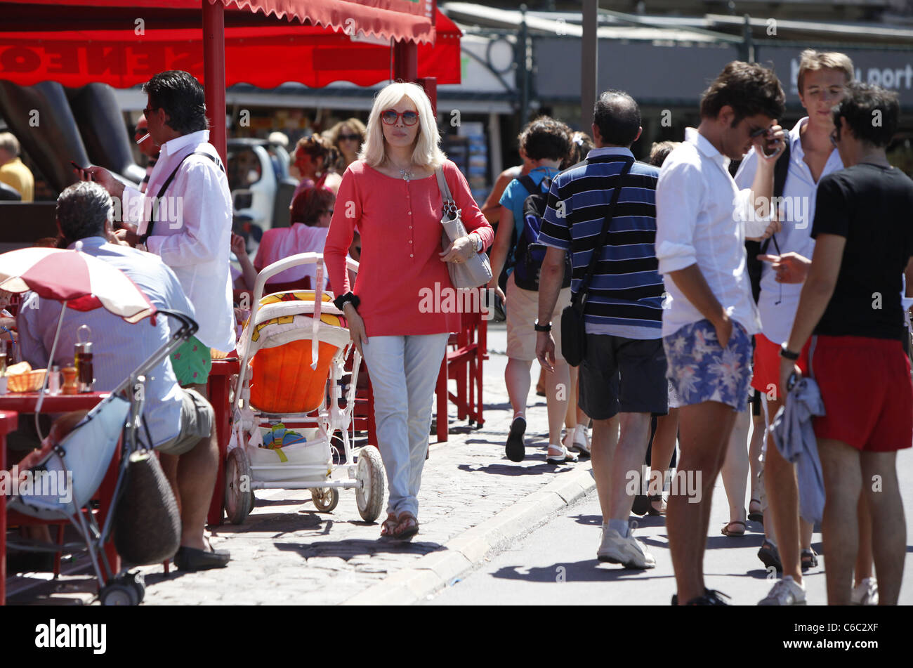 Amanda Lear shopping per le riviste in una giornata di sole a Saint Tropez mentre firma autografi e posa con ventole. Saint Tropez, Foto Stock