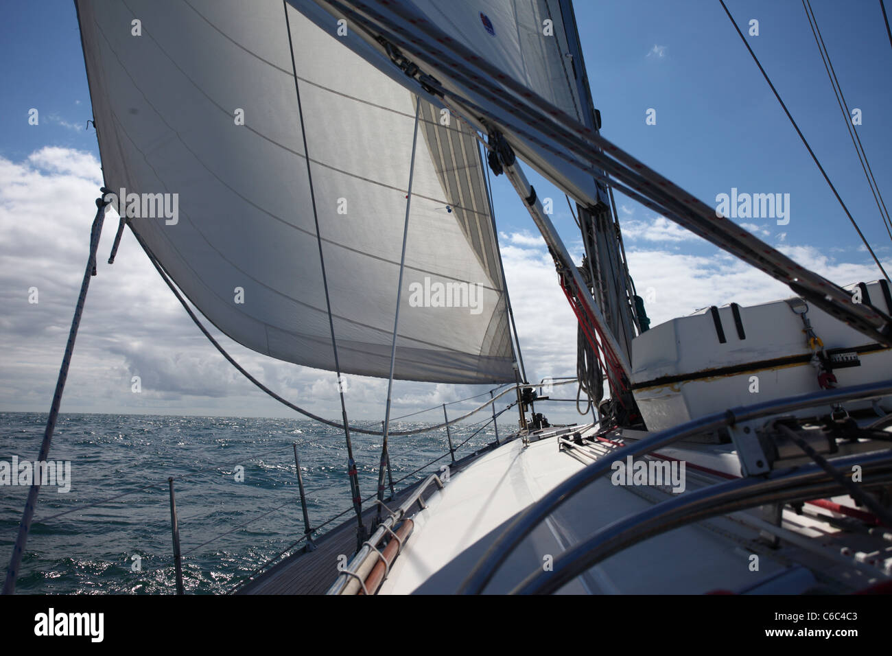 Vela su uno yacht a vela contro un cielo azzurro e sole Foto Stock
