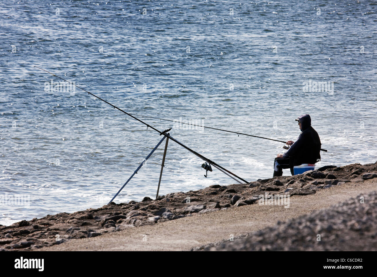 Il pescatore pesca in mare da dyke, Paesi Bassi Foto Stock