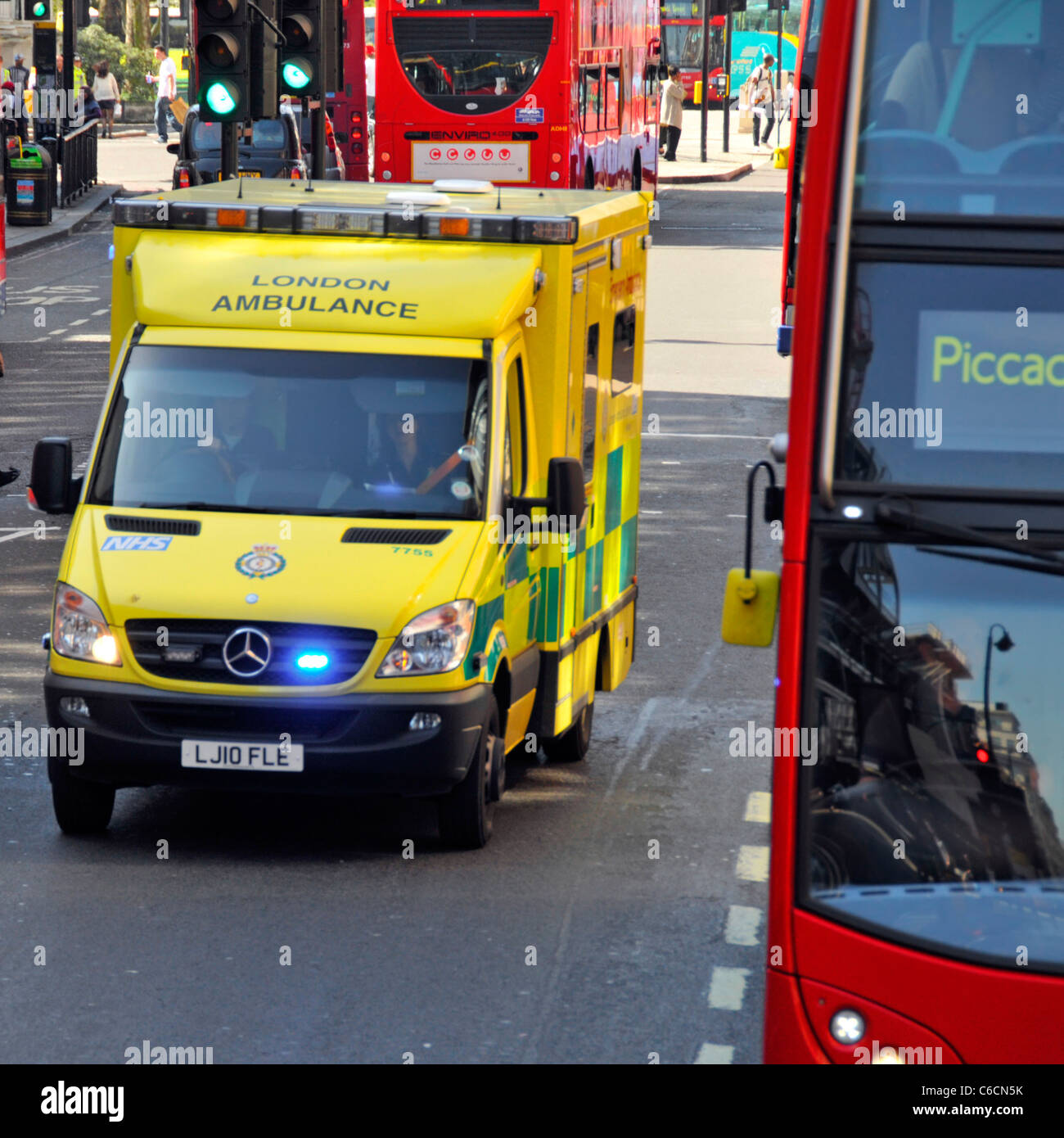 Ambulanza Londra REGNO UNITO Inghilterra & driver su 999 SOS chiamata di emergenza passando London bus rosso a due piani Foto Stock