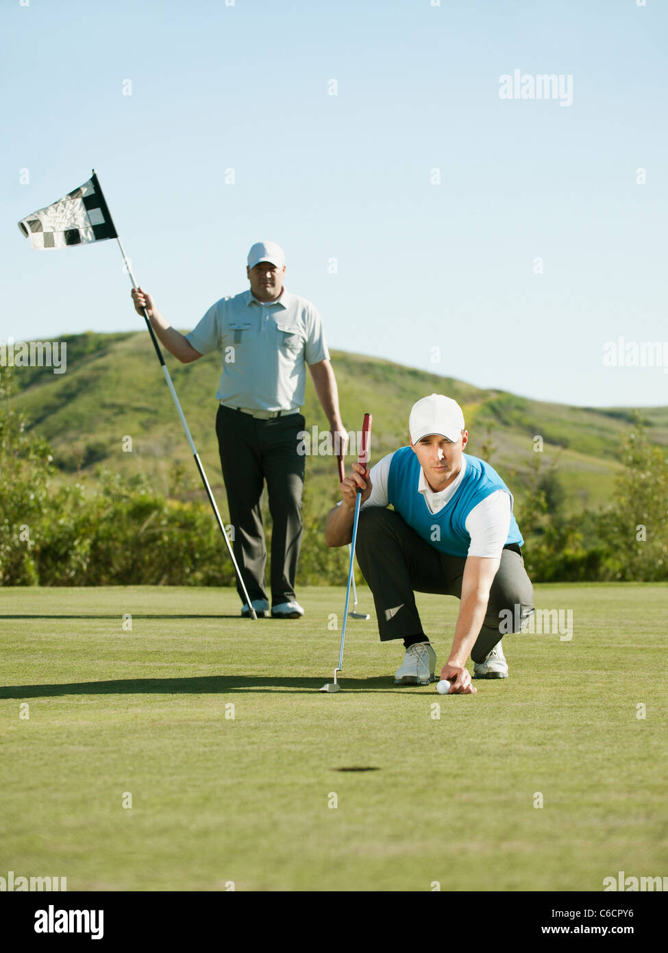 Golfista caucasica posizionando la pallina da golf sul corso Foto Stock