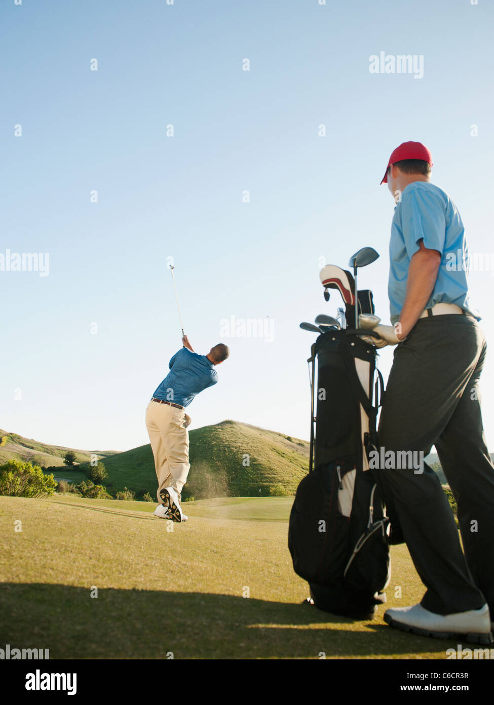 Gli uomini che giocano a golf sul campo da golf Foto Stock