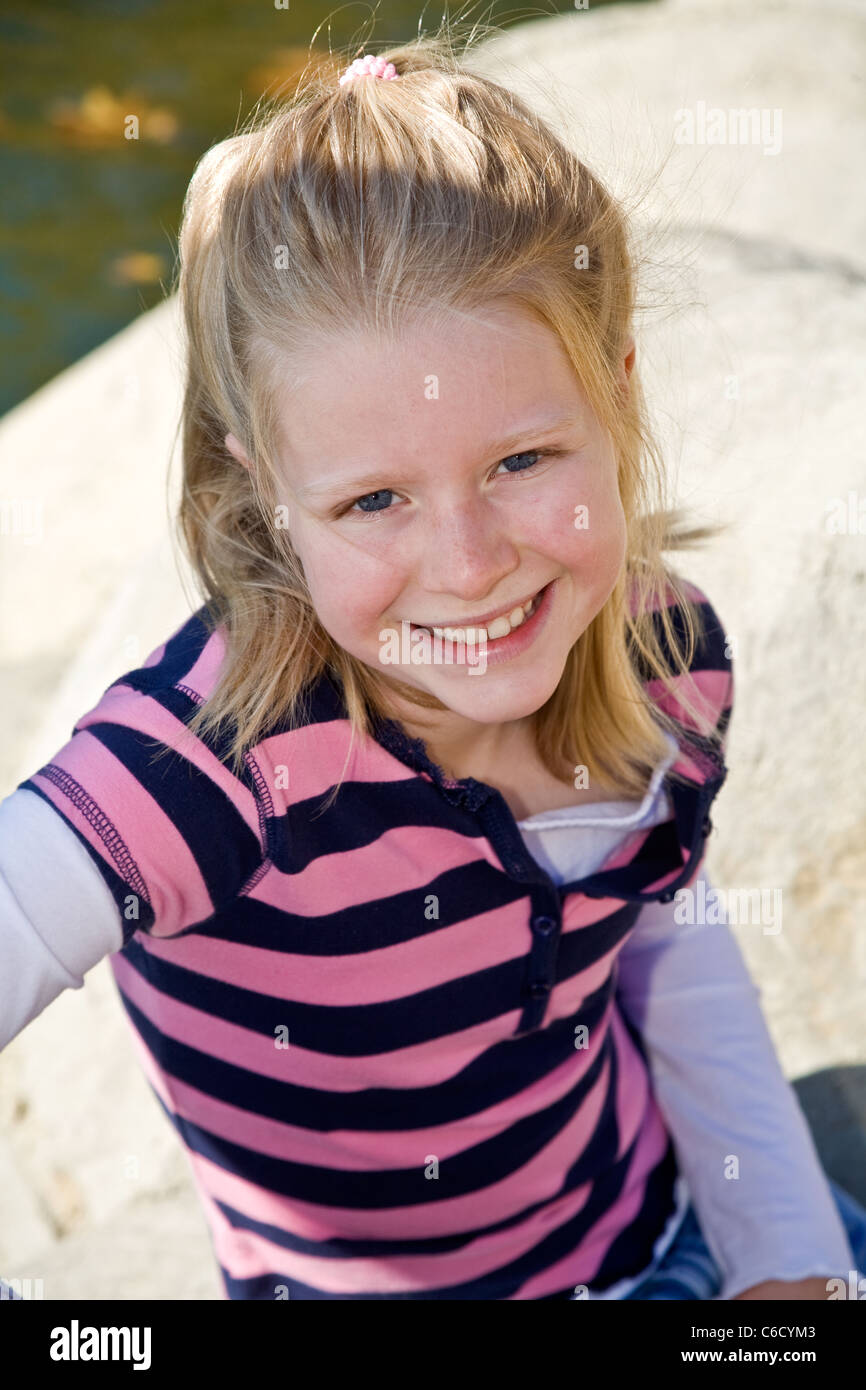 Caucasian ragazza bionda 8-10 anni vecchia ragazza in park cercando fino alla fotocamera.elevato angolo da sopra il signor © Myrleen Pearson Foto Stock