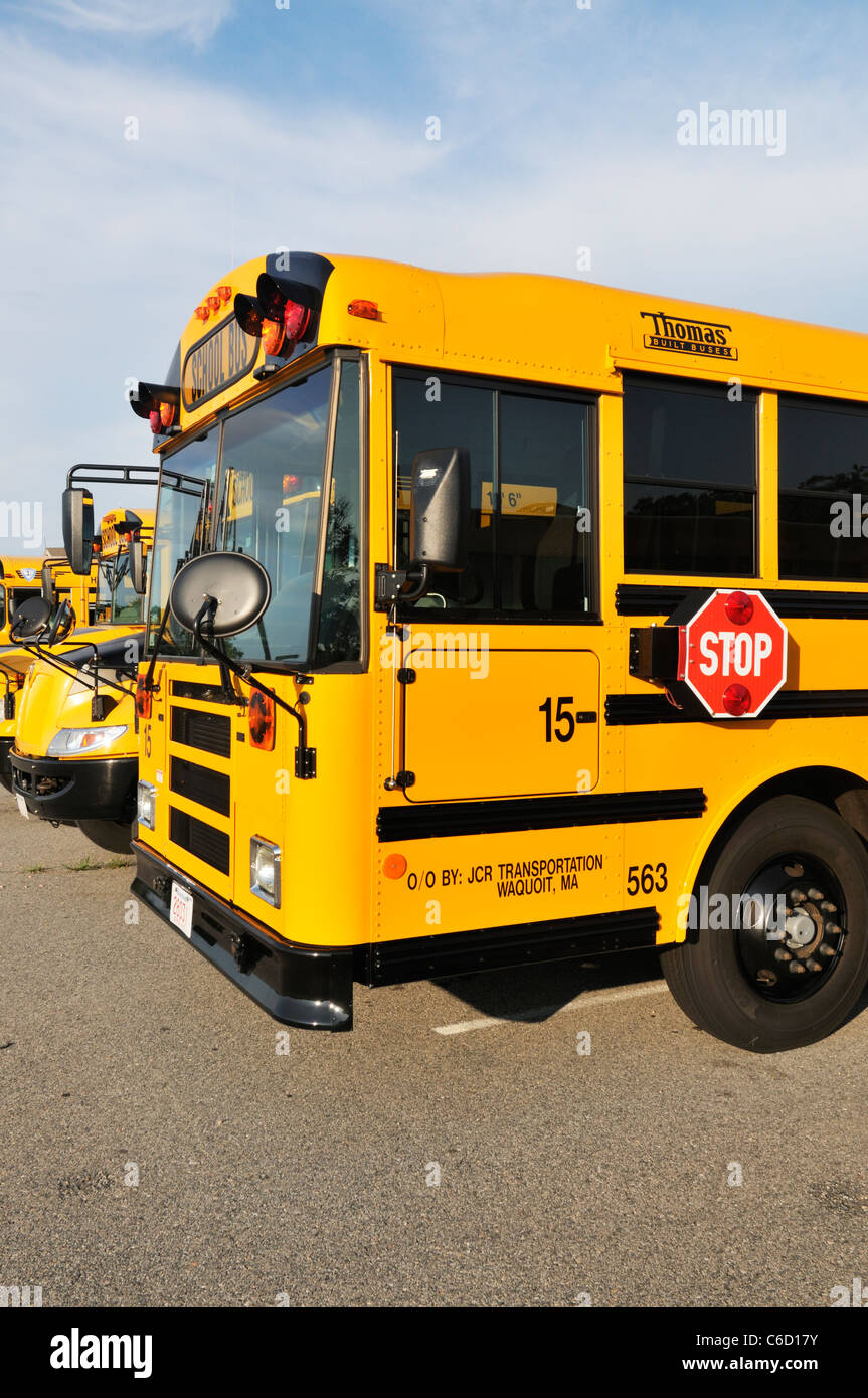 Vista anteriore e laterale del giallo scuola americana di autobus parcheggiati in linea, STATI UNITI D'AMERICA. Foto Stock