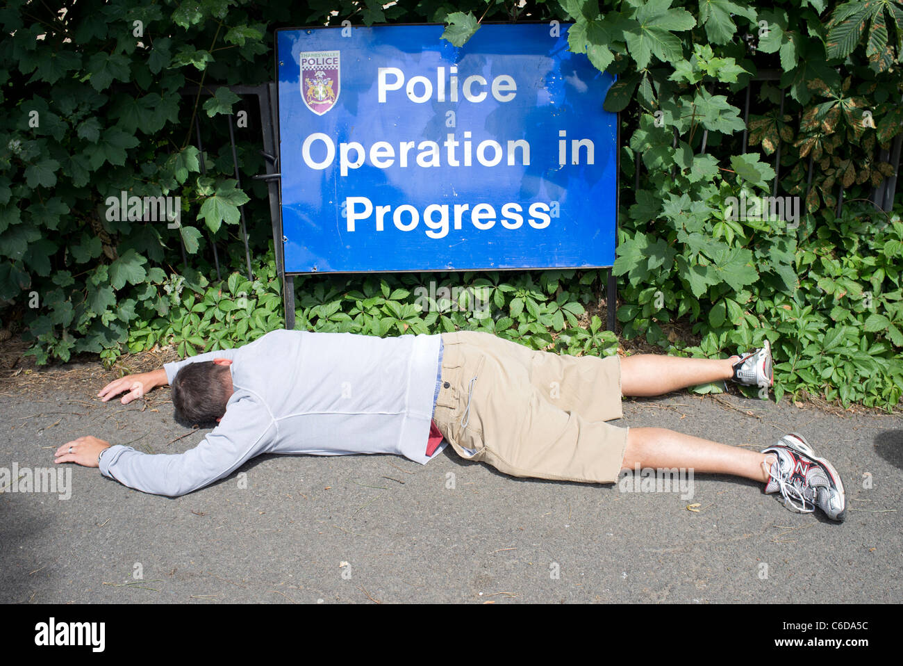 Maschio bianco che giace morto sul marciapiede , operazione di polizia in segno di progresso Foto Stock