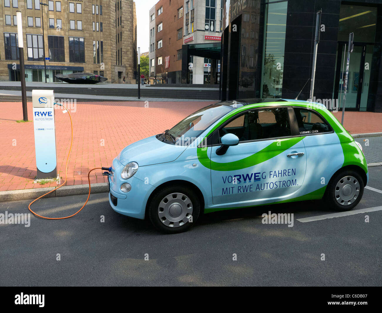 Fiat 500 auto elettrica di proprietà dell'azienda elettrica RWE essere ricaricati sulla strada di Dortmund Germania Foto Stock