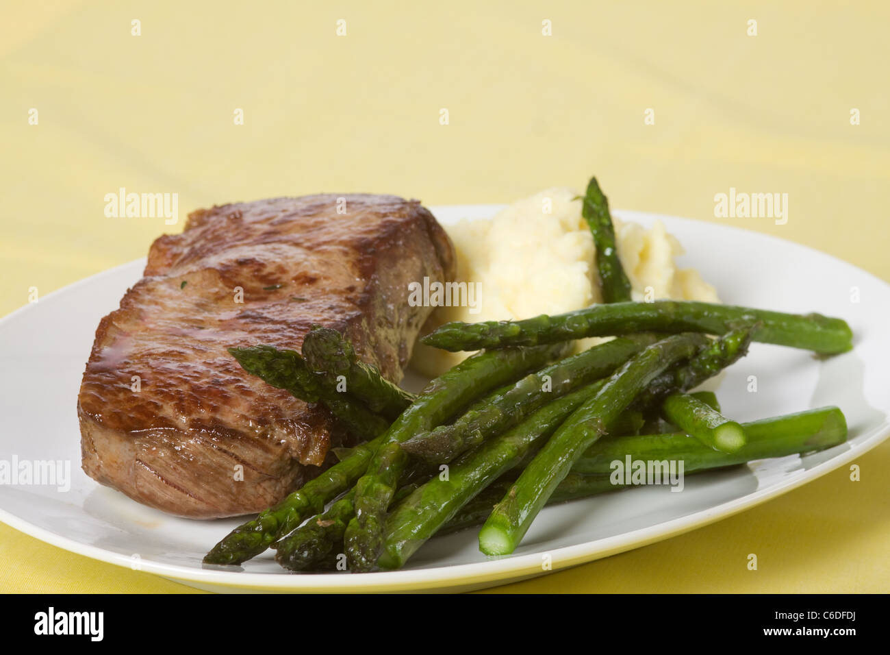 Lombata di manzo con patatine fritte asparagi verdi Foto Stock