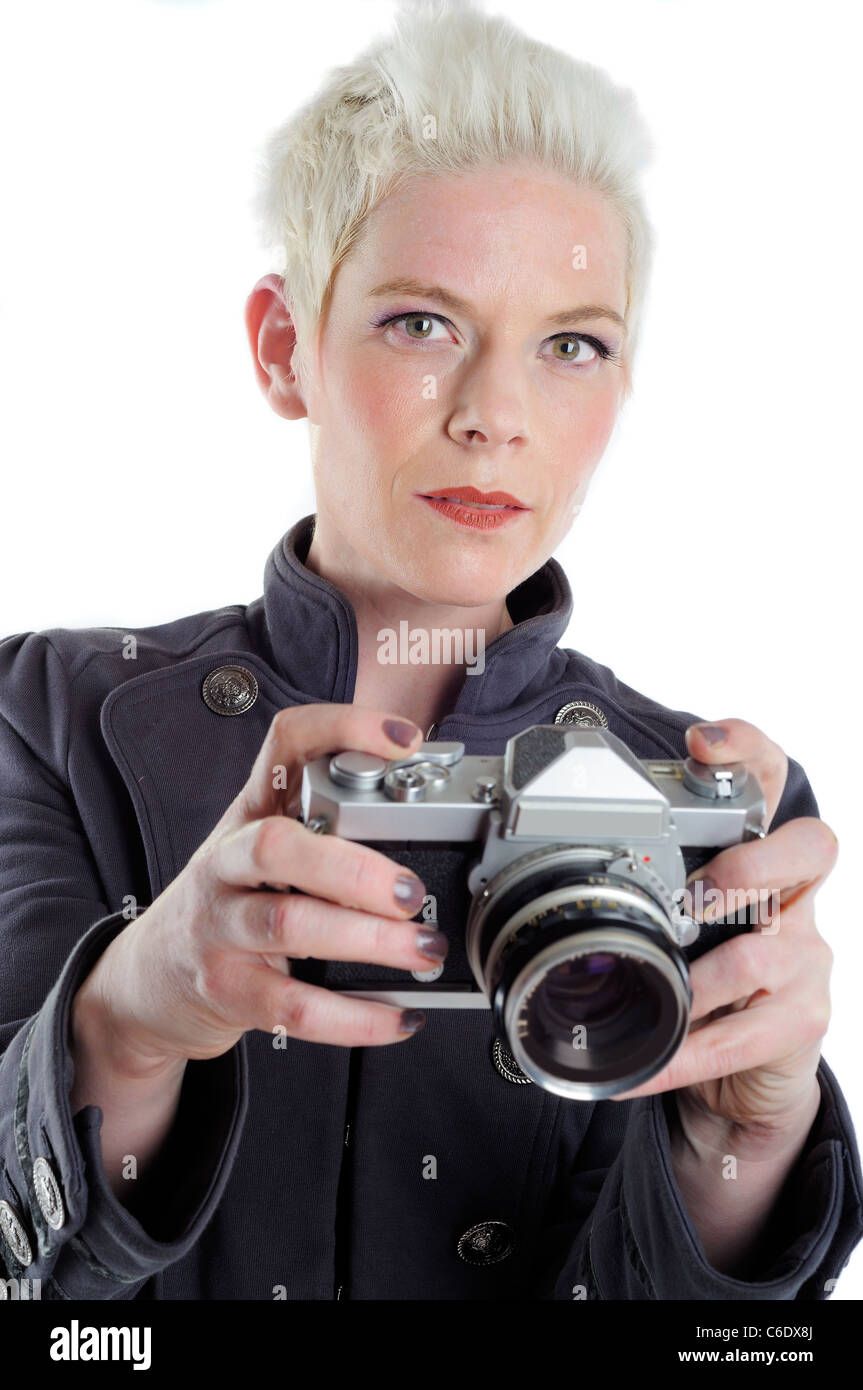 Bella dai capelli corti donna bionda tenendo un retrò SLR Fotocamera Foto Stock
