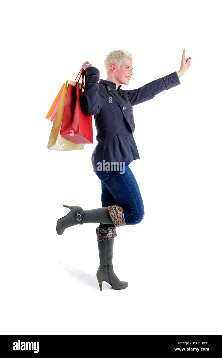Capelli corti donna bionda azienda colorato Shopping Bags salutando un Taxi Foto Stock