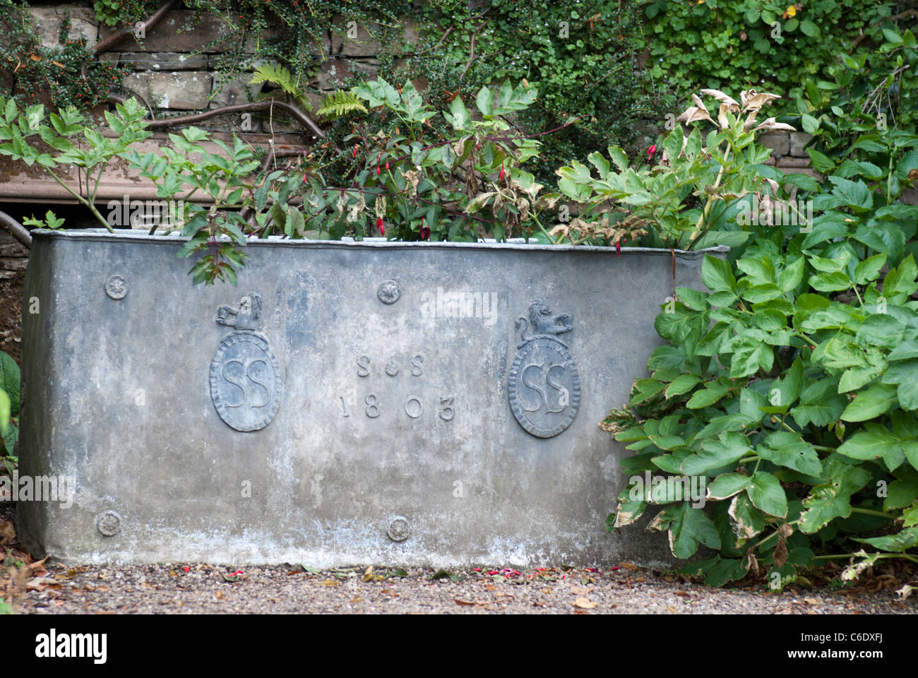 Metallo vecchio trogolo di acqua,datata 1803 e recanti la cresta della famiglia Sitwell nei giardini della Renishaw Hall, vicino a Sheffield Foto Stock