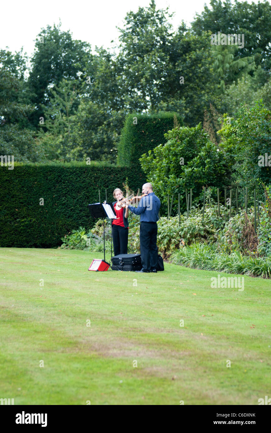 Due violinista intrattenere i visitatori a Renishaw Hall, Derbyshire, Inghilterra, Regno Unito. Foto Stock