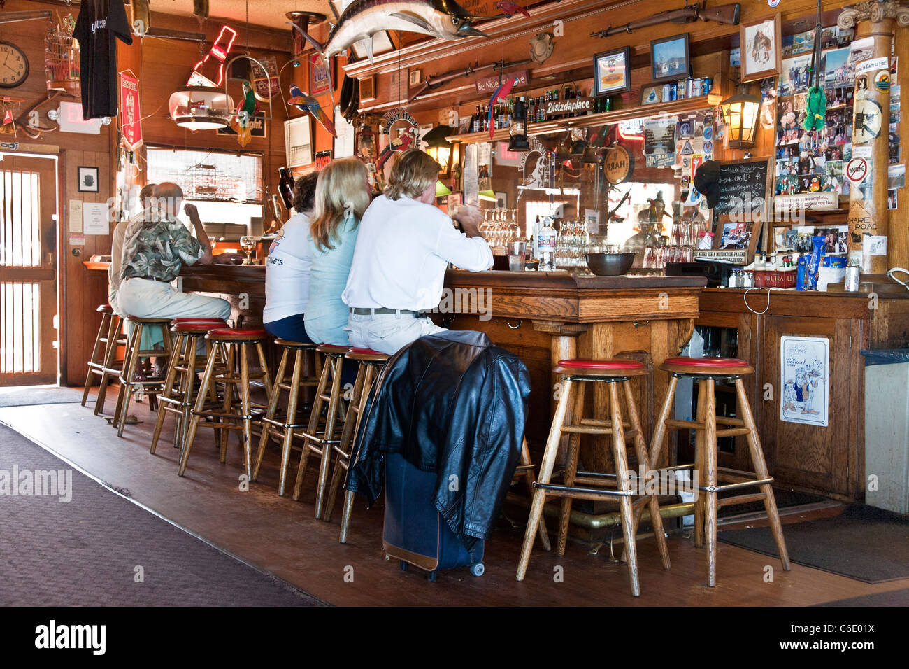 La gente seduta a riccamente intagliati in legno vintage bar decorato con memorabilia sportivi nella vecchia taverna Coupeville Washington Foto Stock