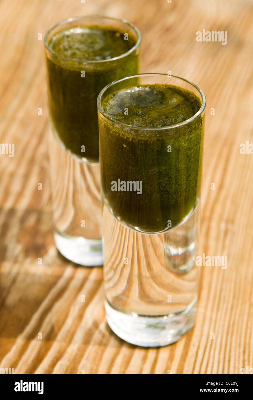 Due bicchierini di juiced ortica pronto da bere, utilizzato come una bevanda di salute Foto Stock