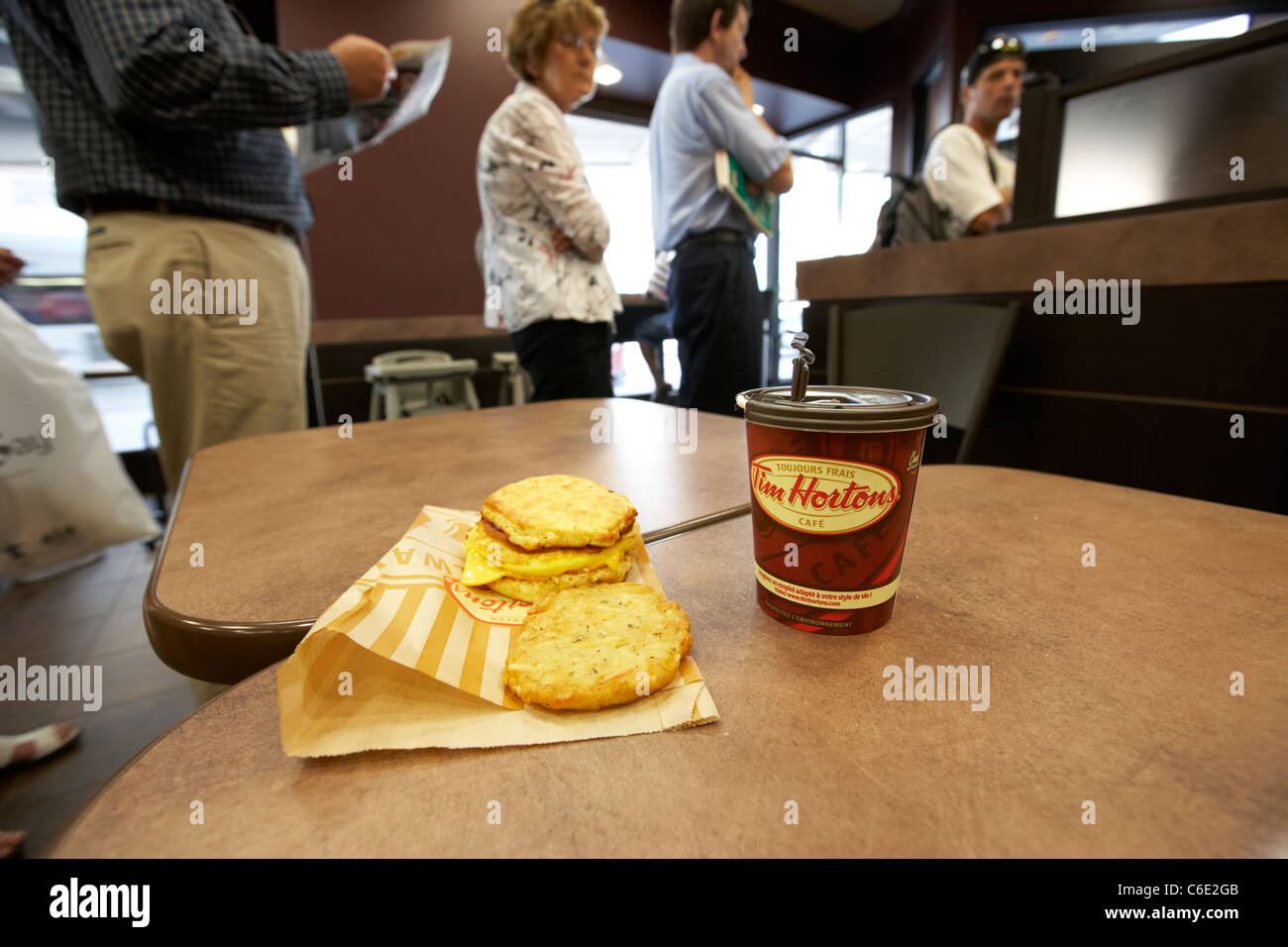 Persone queueing passato medie caffè e colazione in Tim Hortons coffee shop in Canada Foto Stock