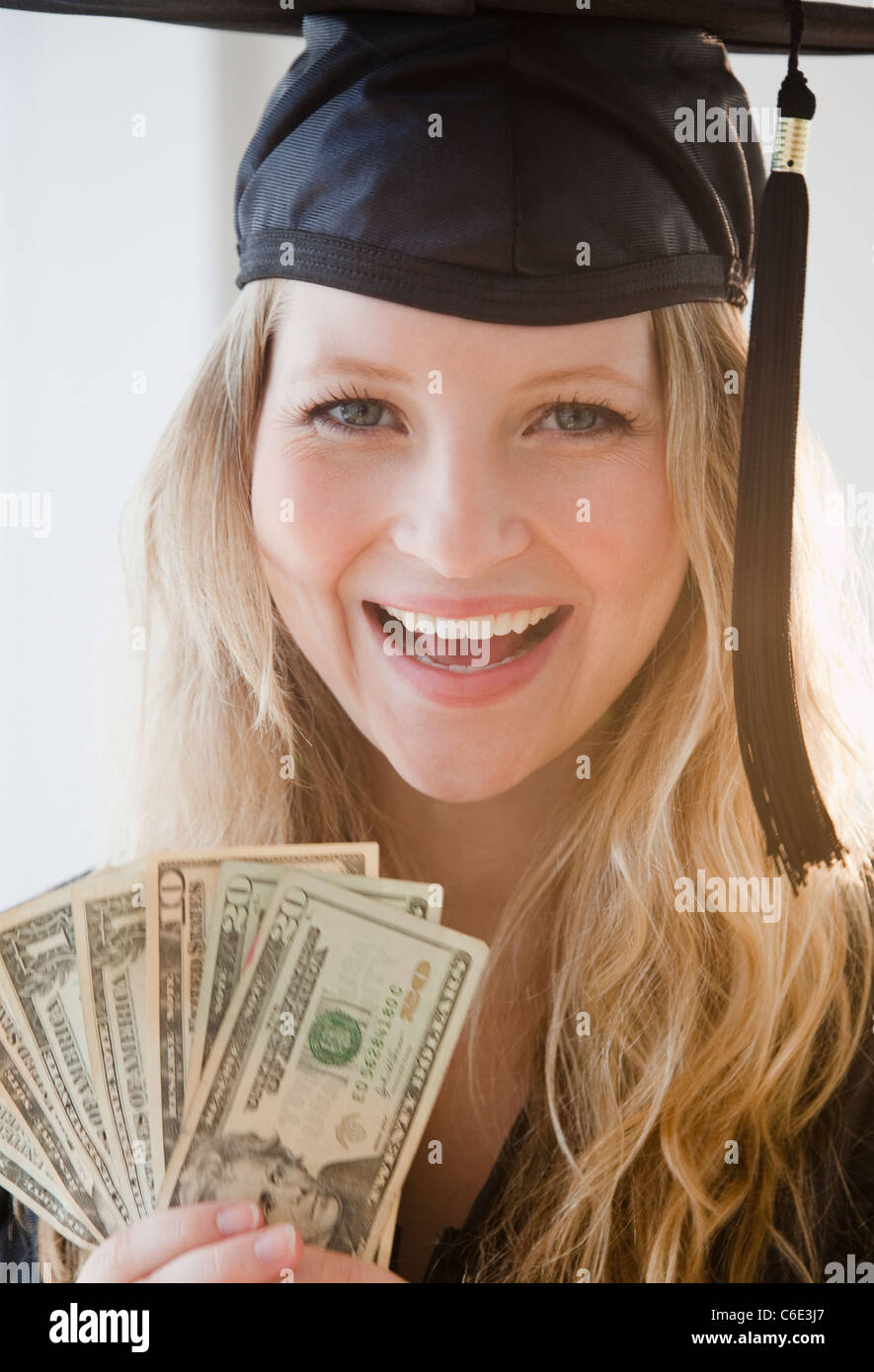 Stati Uniti d'America, New Jersey, Jersey City, giovane donna indossa abito di graduazione holding banconote Foto Stock