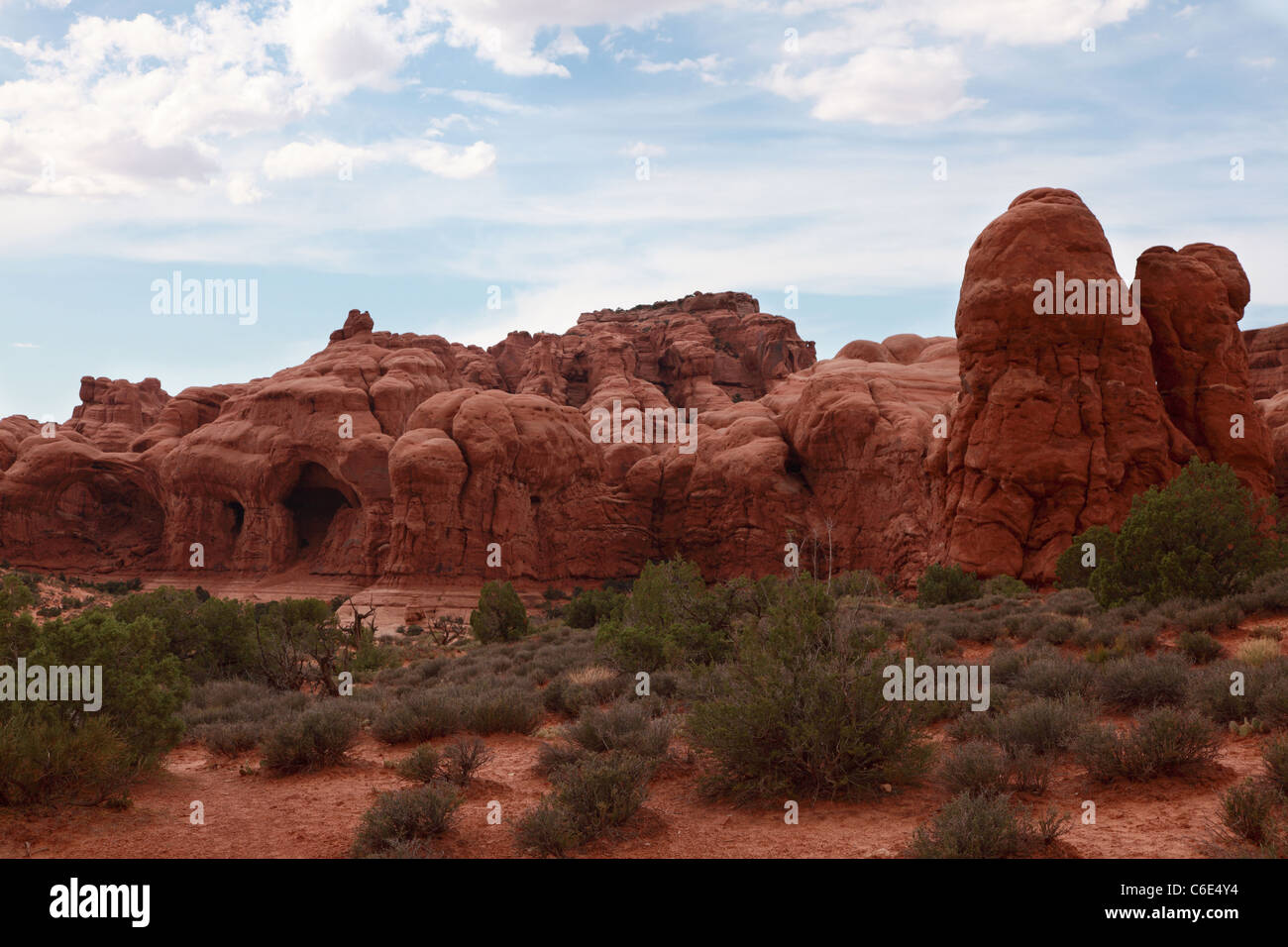 Foto di stock di rosso le formazioni rocciose di nome "Cove di grotte", situato nel Parco Nazionale di Arches in Moab Utah. Foto Stock