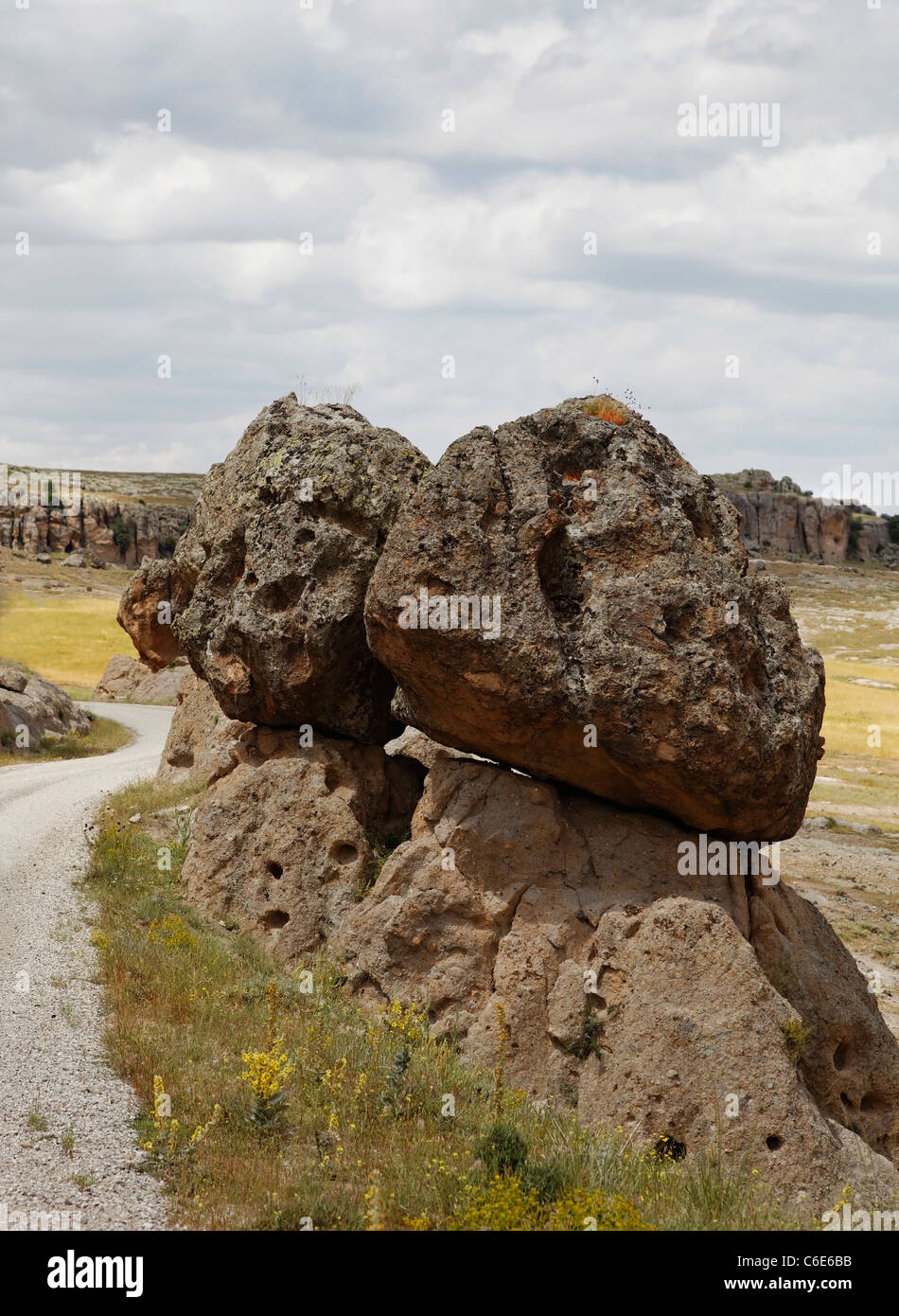 Lava vulcanica massi di cenere in condizioni di equilibrio precario su uno un altro una pericolosa valanga feature su sterrato in Cappadocia Turchia Foto Stock