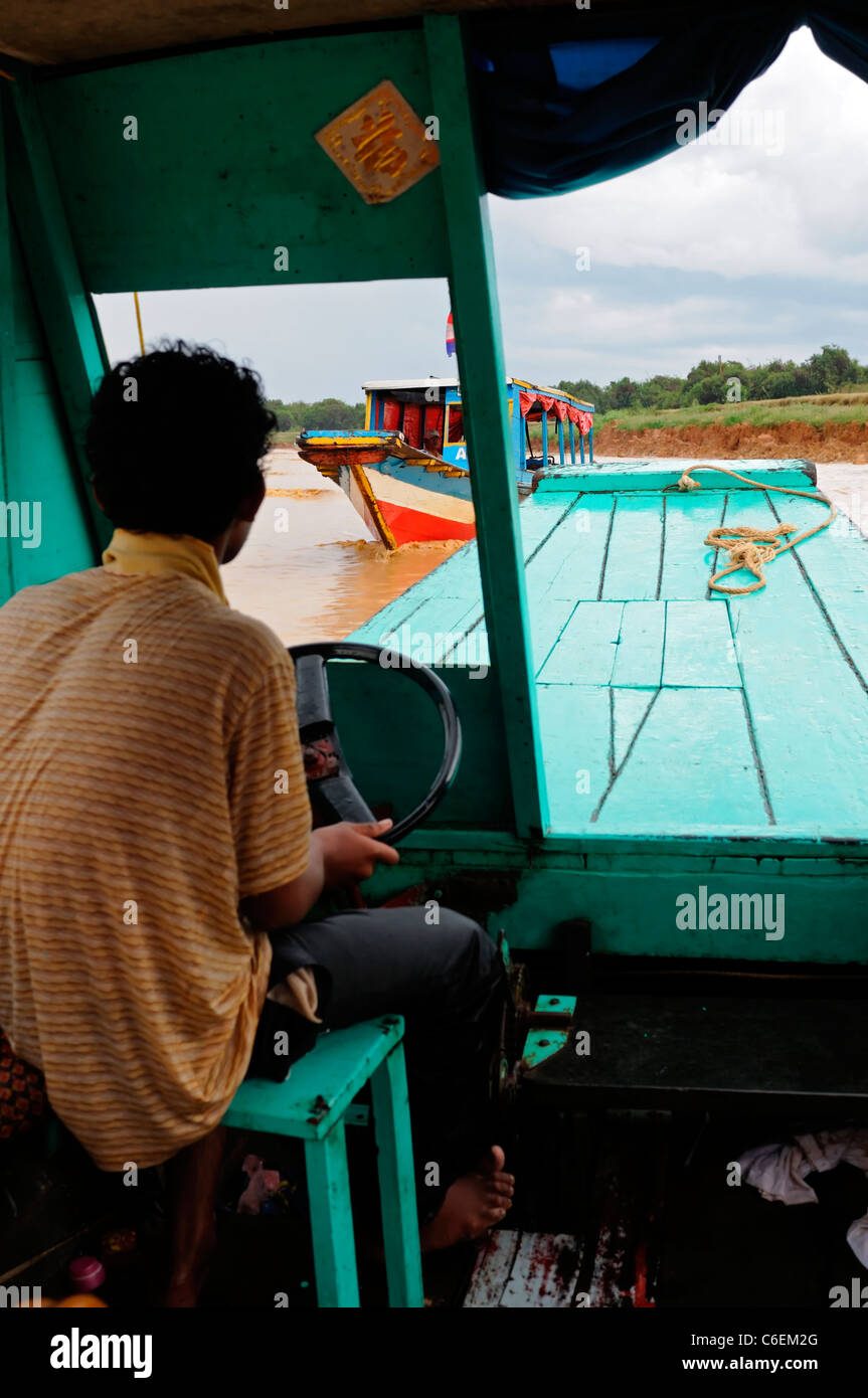 Il Tonle Sap lago d'acqua dolce siem reap cambogia houseboat uomo vela vela drive tour tourist Foto Stock