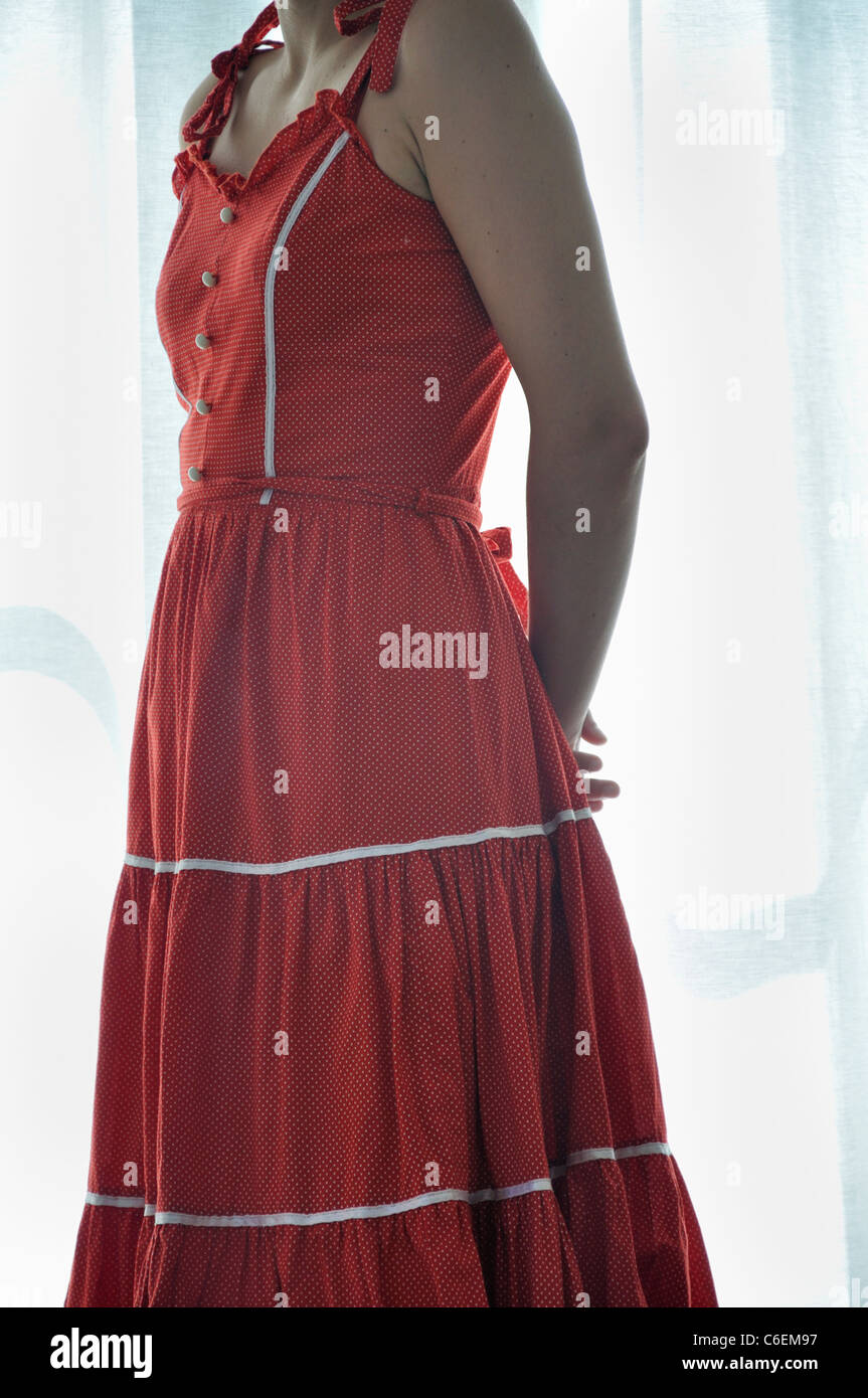 Giovane donna in piedi presso la finestra Foto Stock