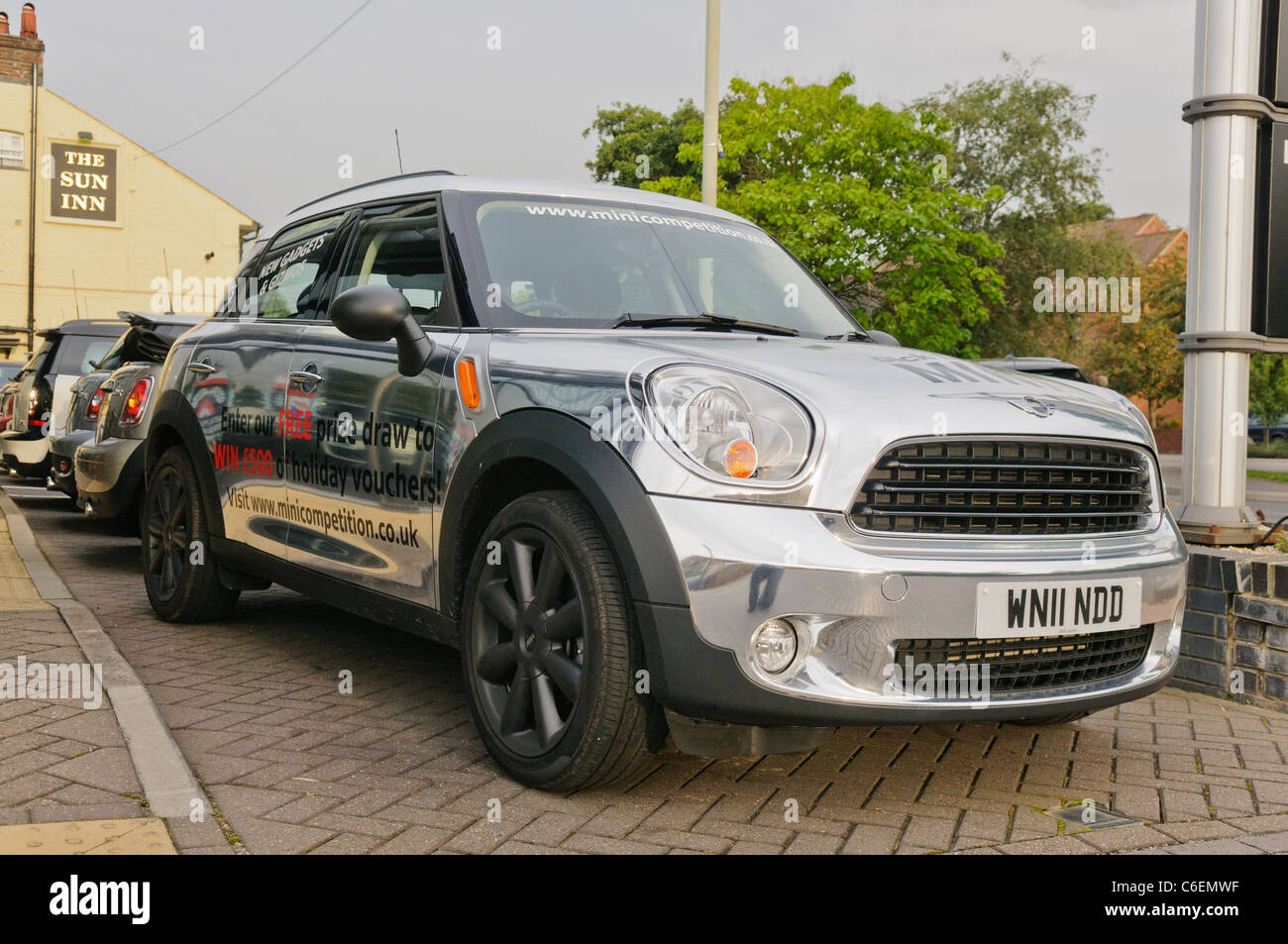 Una BMW MINI Countryman dipinta con altamente riflettente argento vernice speculare al di fuori di un concessionario Foto Stock