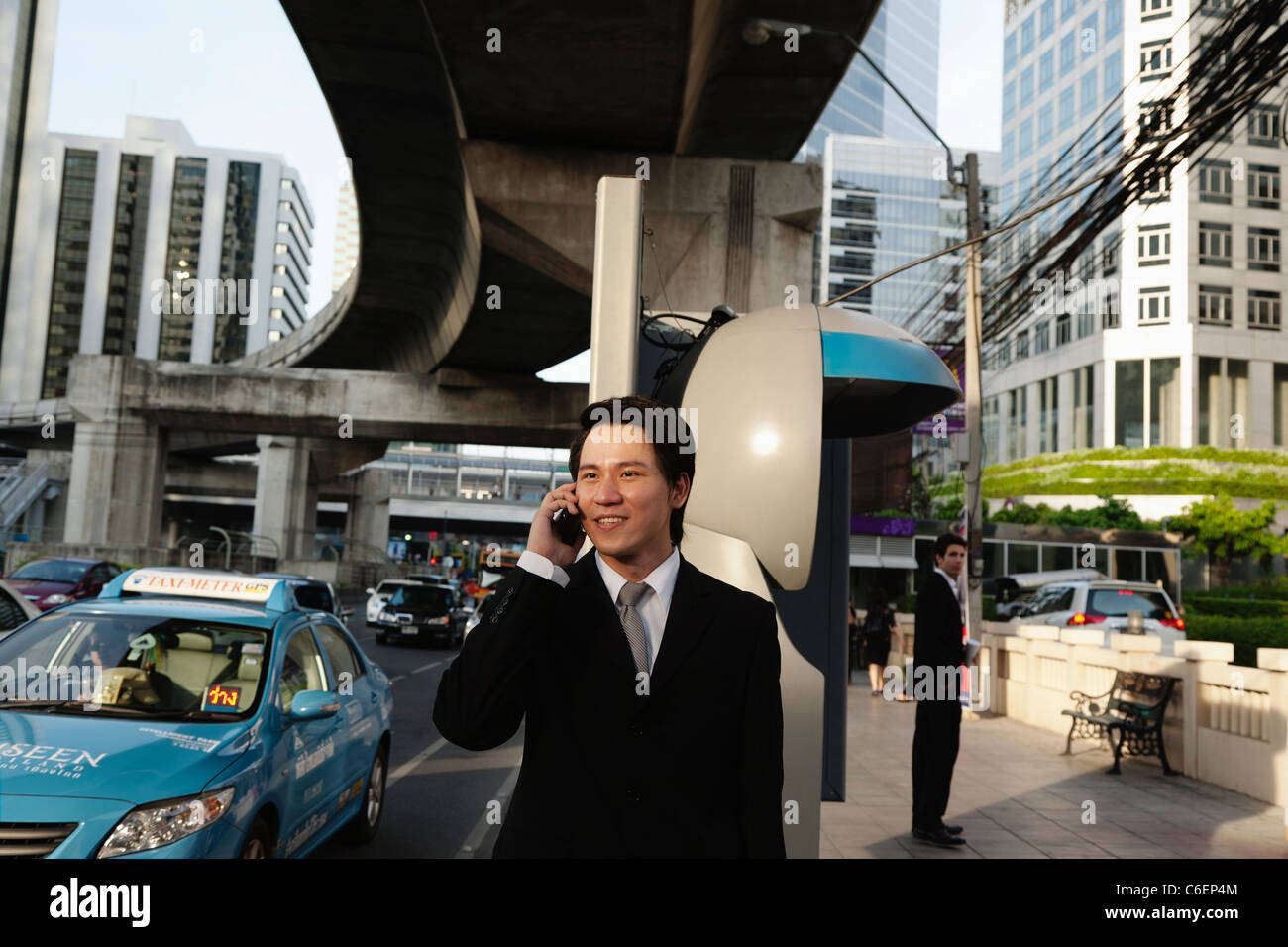 Imprenditore asiatici parlando al cellulare all'aperto Foto Stock