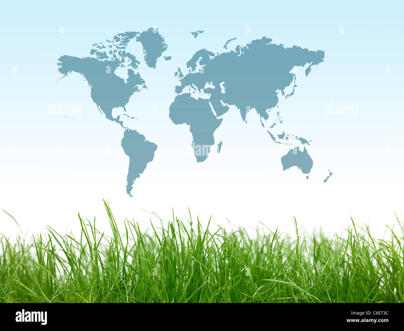 Erba verde isolata contro un cielo blu con una mappa del mondo Foto Stock