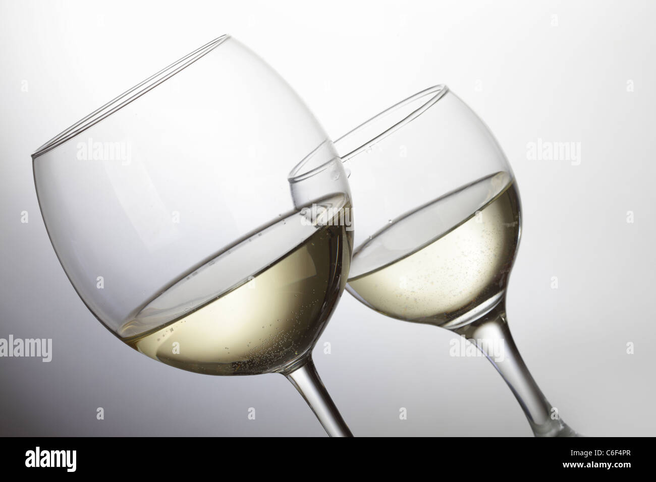 Due bicchieri di vino bianco su sfondo grigio chiaro Foto Stock